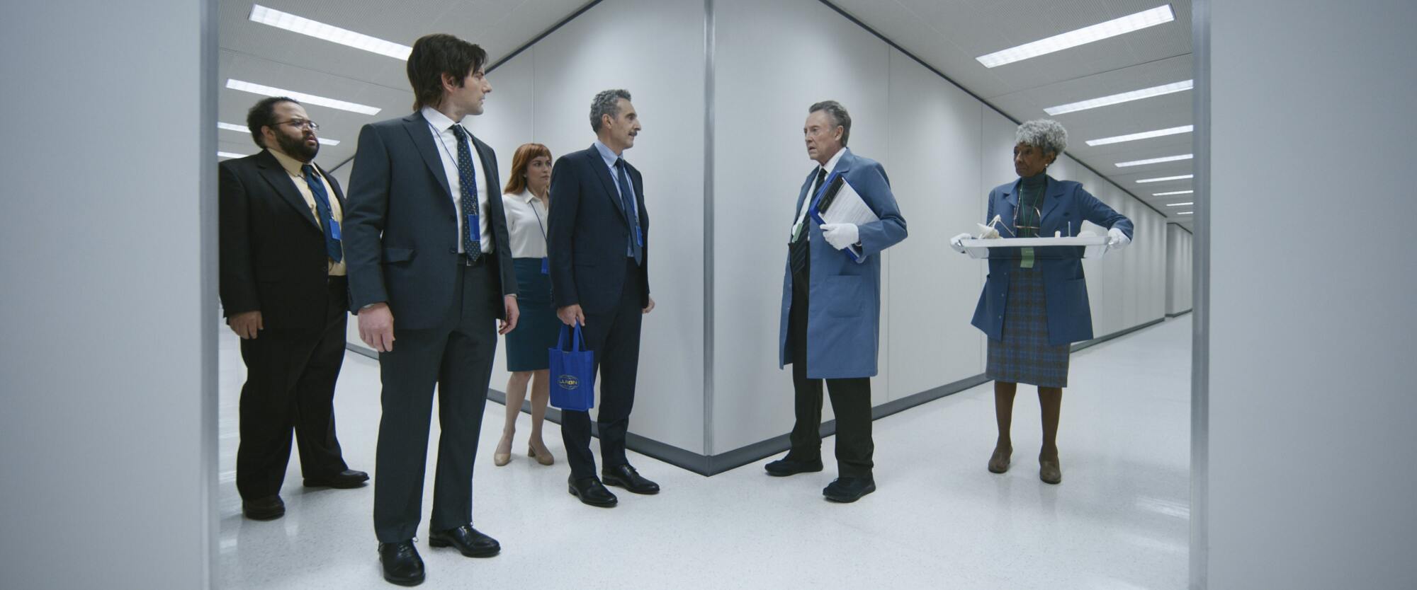 Les stars d'Apple TV+ "Rupture" debout ensemble dans un couloir blanc.