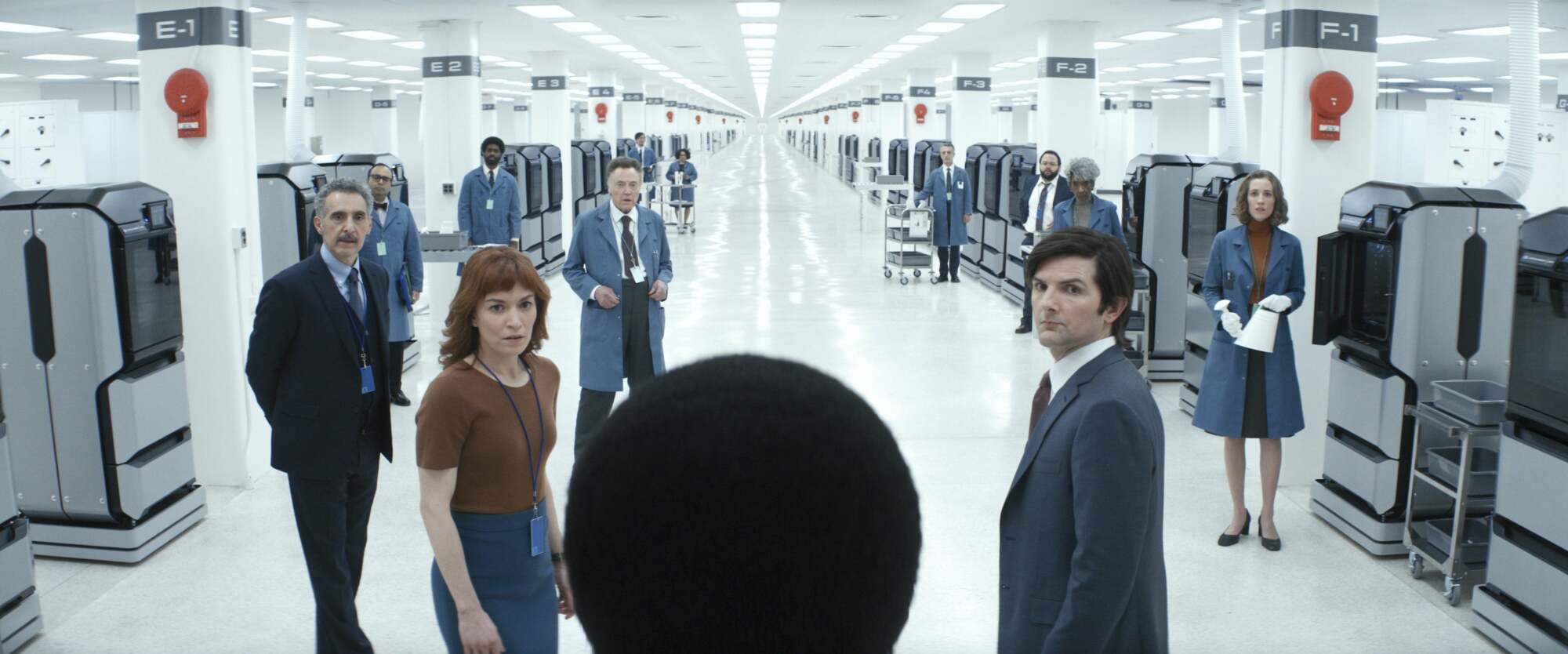 Le casting d'Apple TV+ "Rupture" debout ensemble dans une usine.