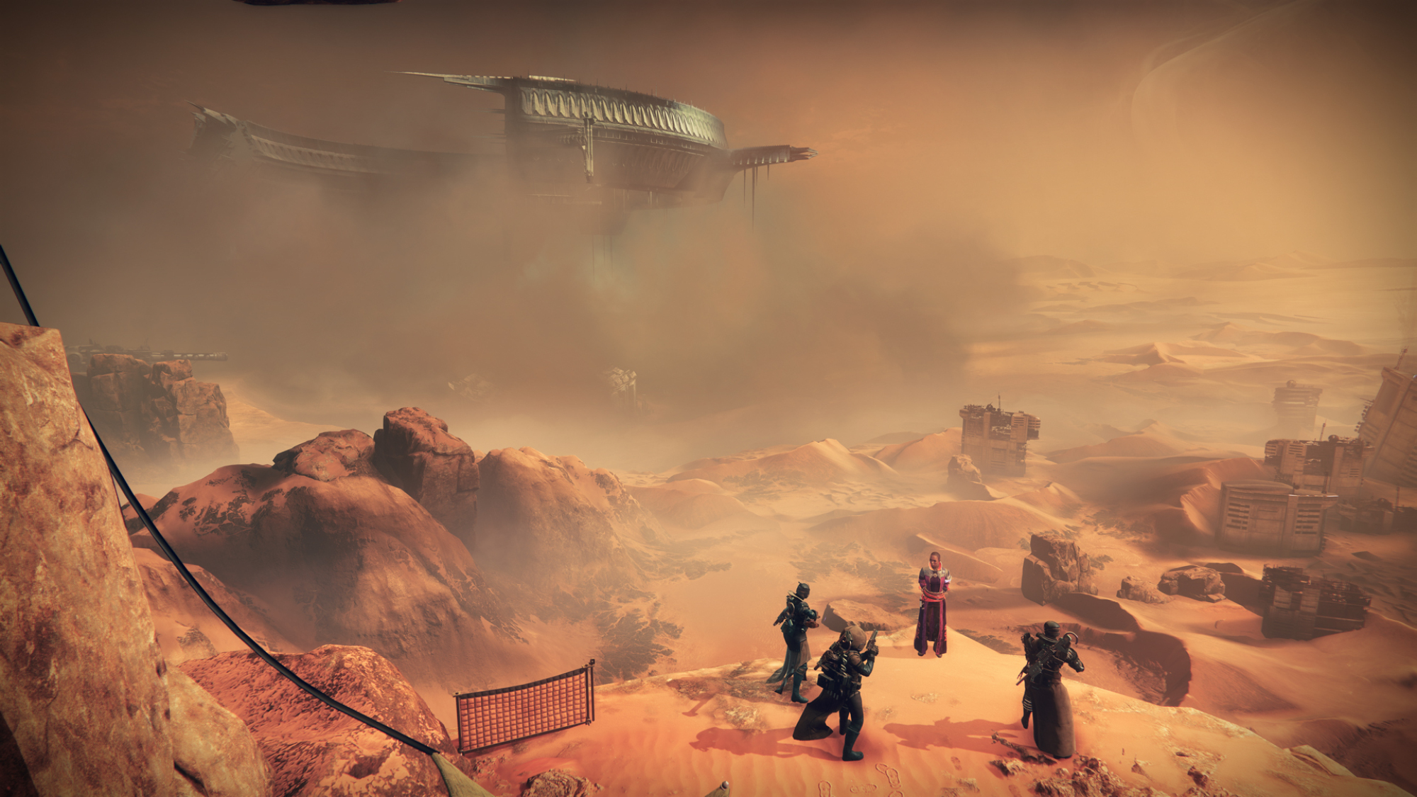 Un paysage désertique sur la planète Mars.  Au premier plan, un petit groupe de personnes se tient sur un plateau, regardant au loin où un énorme vaisseau spatial en forme de cercle est suspendu dans le ciel.