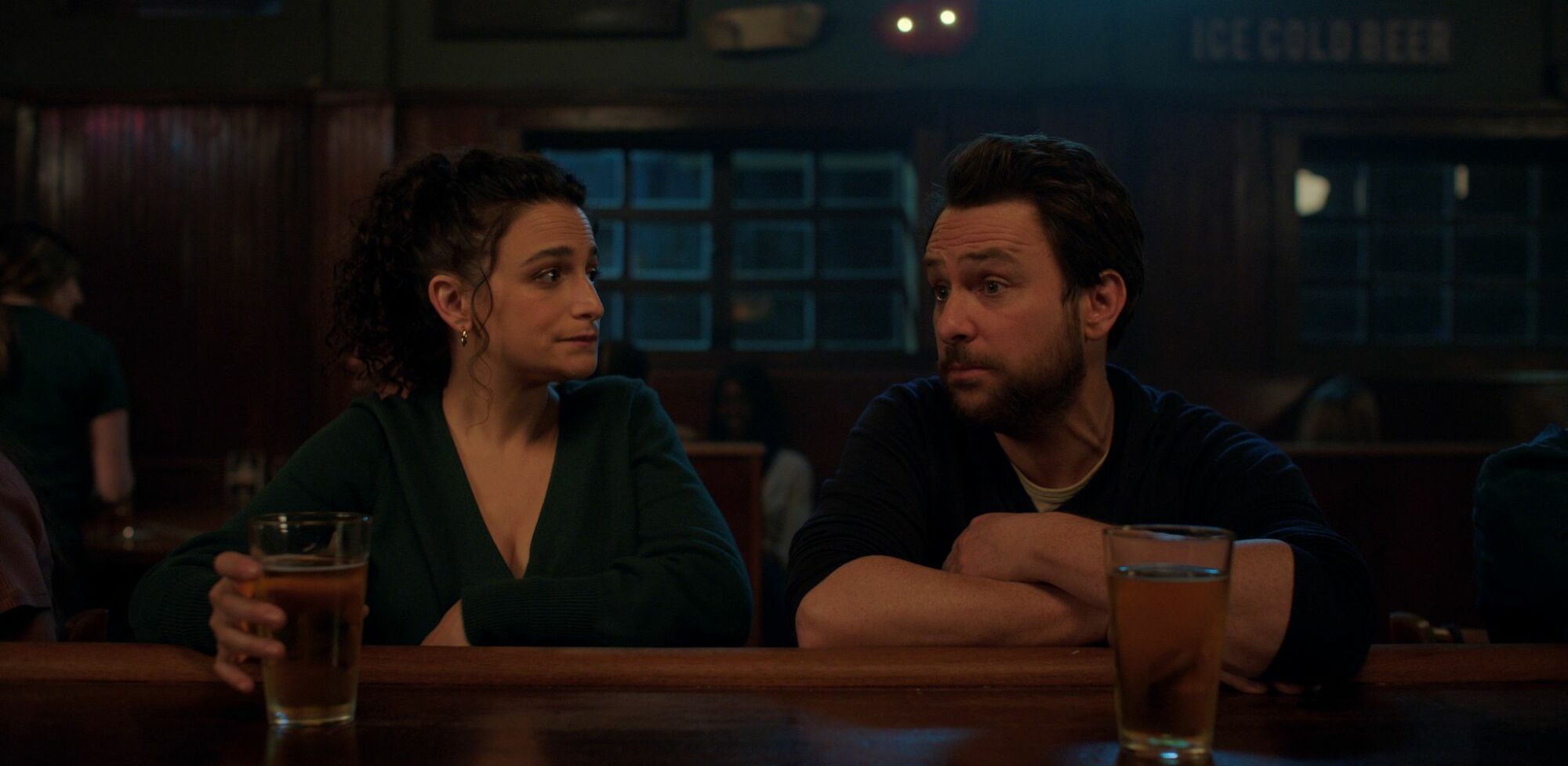 Jenny Slate et Charlie Day sont assis dans un bar dans cette image du film I Want You Back.