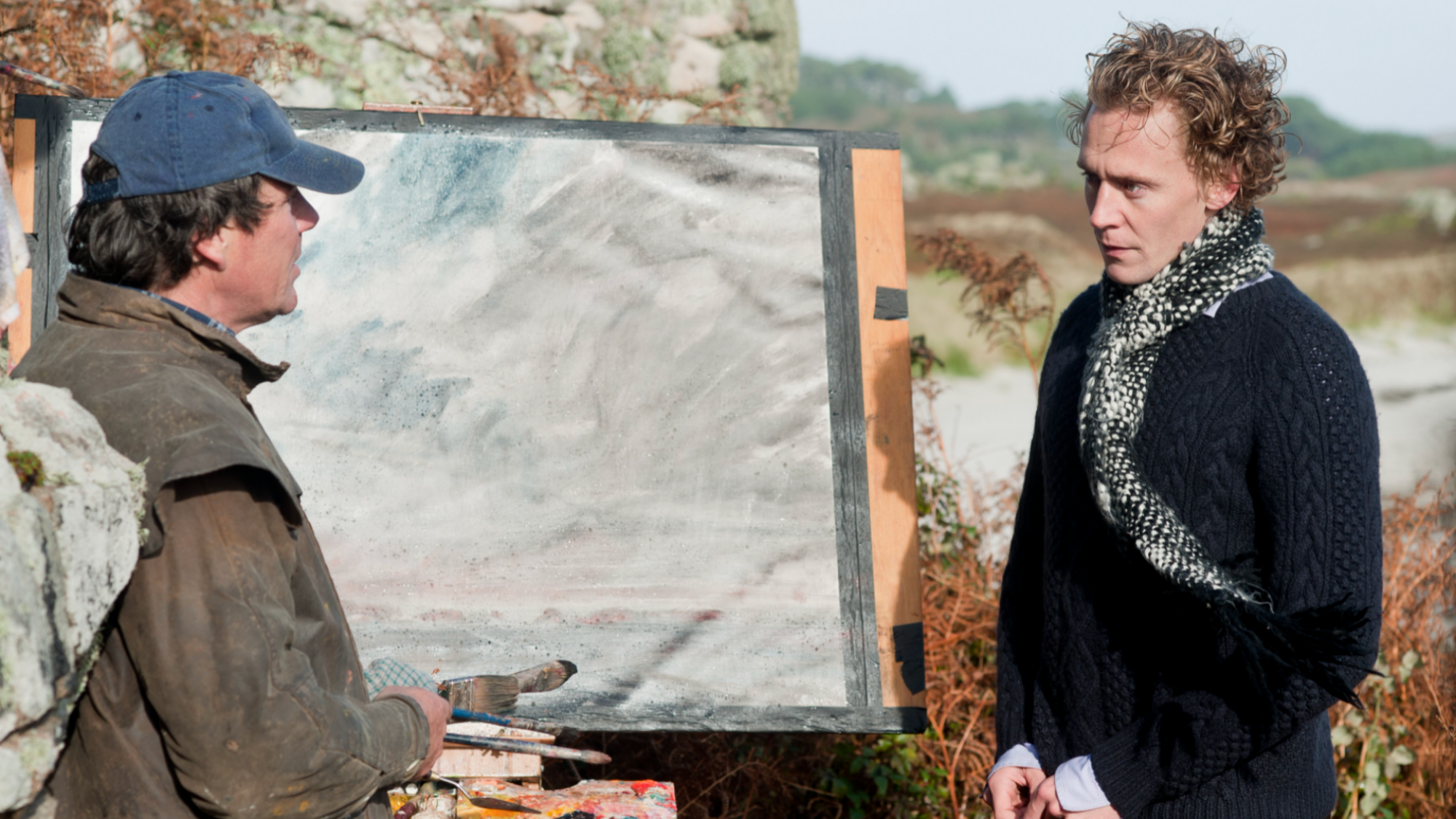 Tom Hiddleston debout à côté d'un peintre dans 'Archipelago'