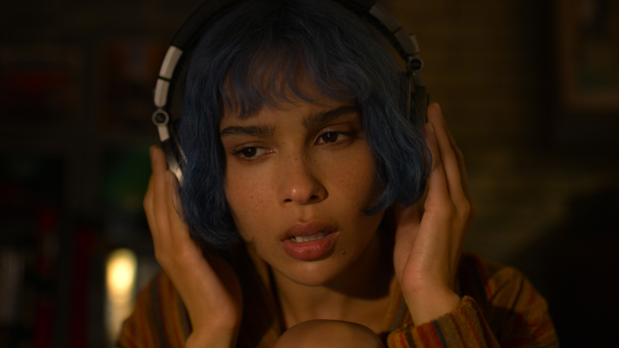 Une fille aux cheveux bleus écoute à l'ancienne sur les écouteurs du cuir chevelu.