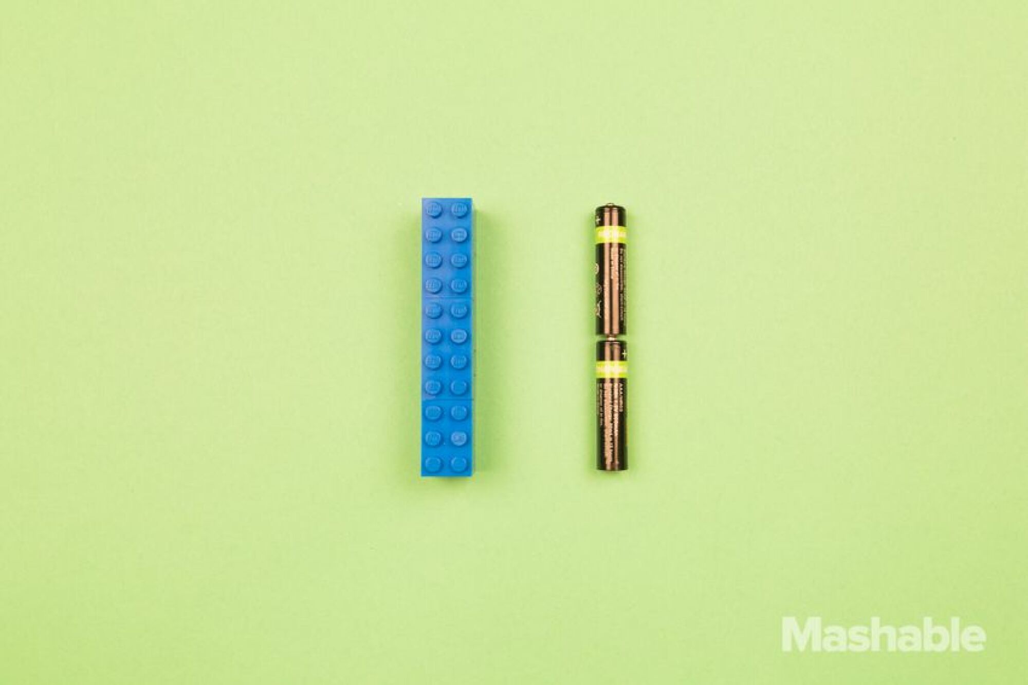 Le Lego bleu à côté de deux batteries. 