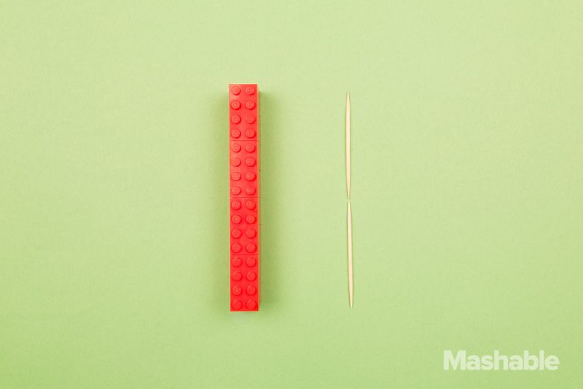 Le Lego rouge à côté de deux cure-dents.