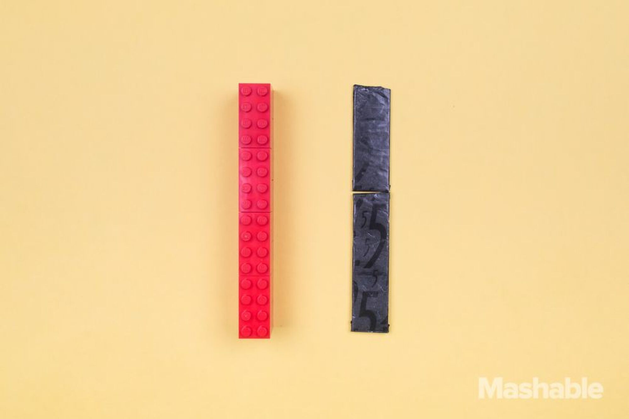 Le Lego rouge à côté de deux bâtons de chewing-gum, dont l'un a été légèrement raccourci.