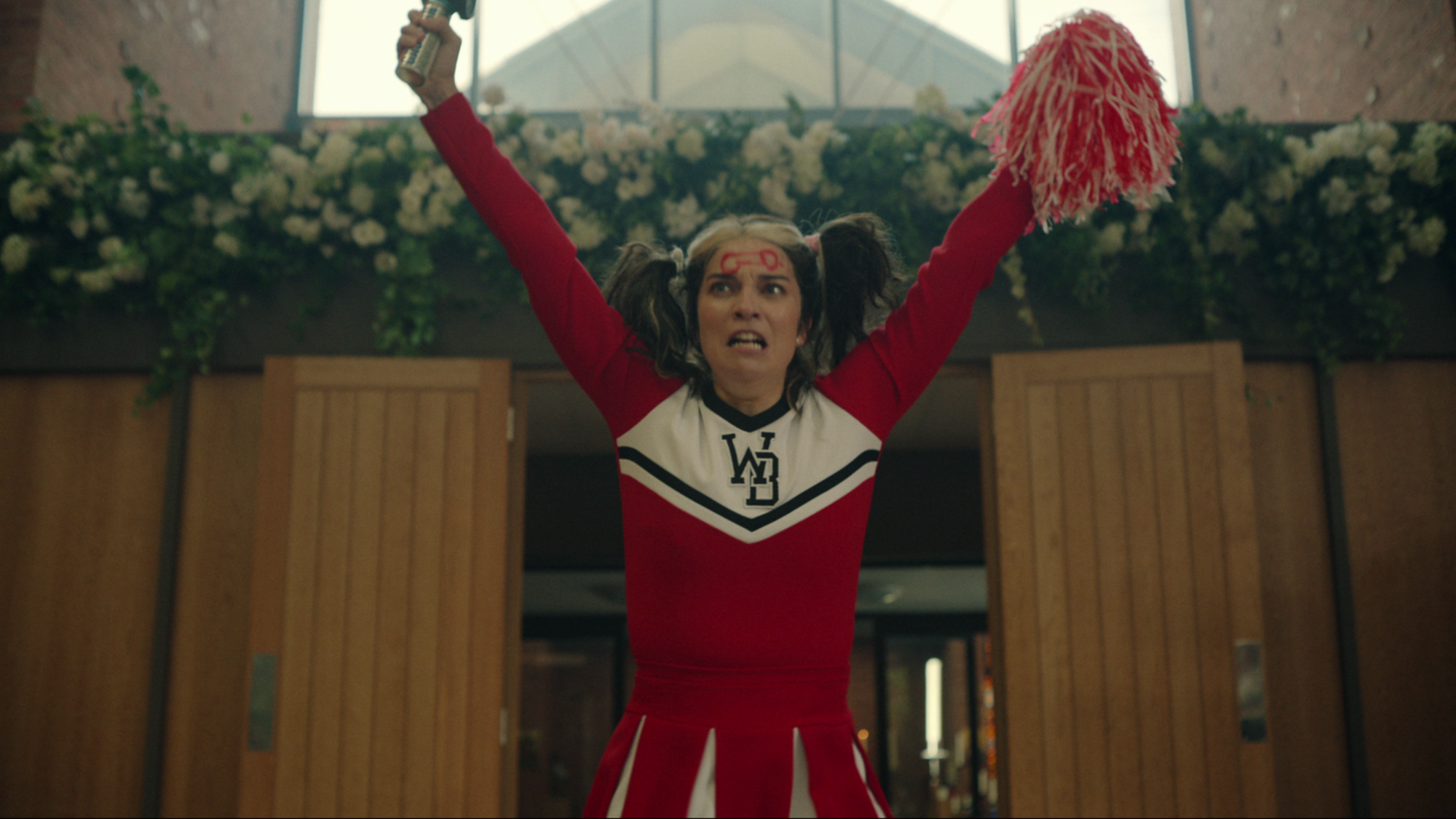 Une femme portant un uniforme de pom-pom girl avec un pénis dessiné sur son front fait irruption dans une église. 