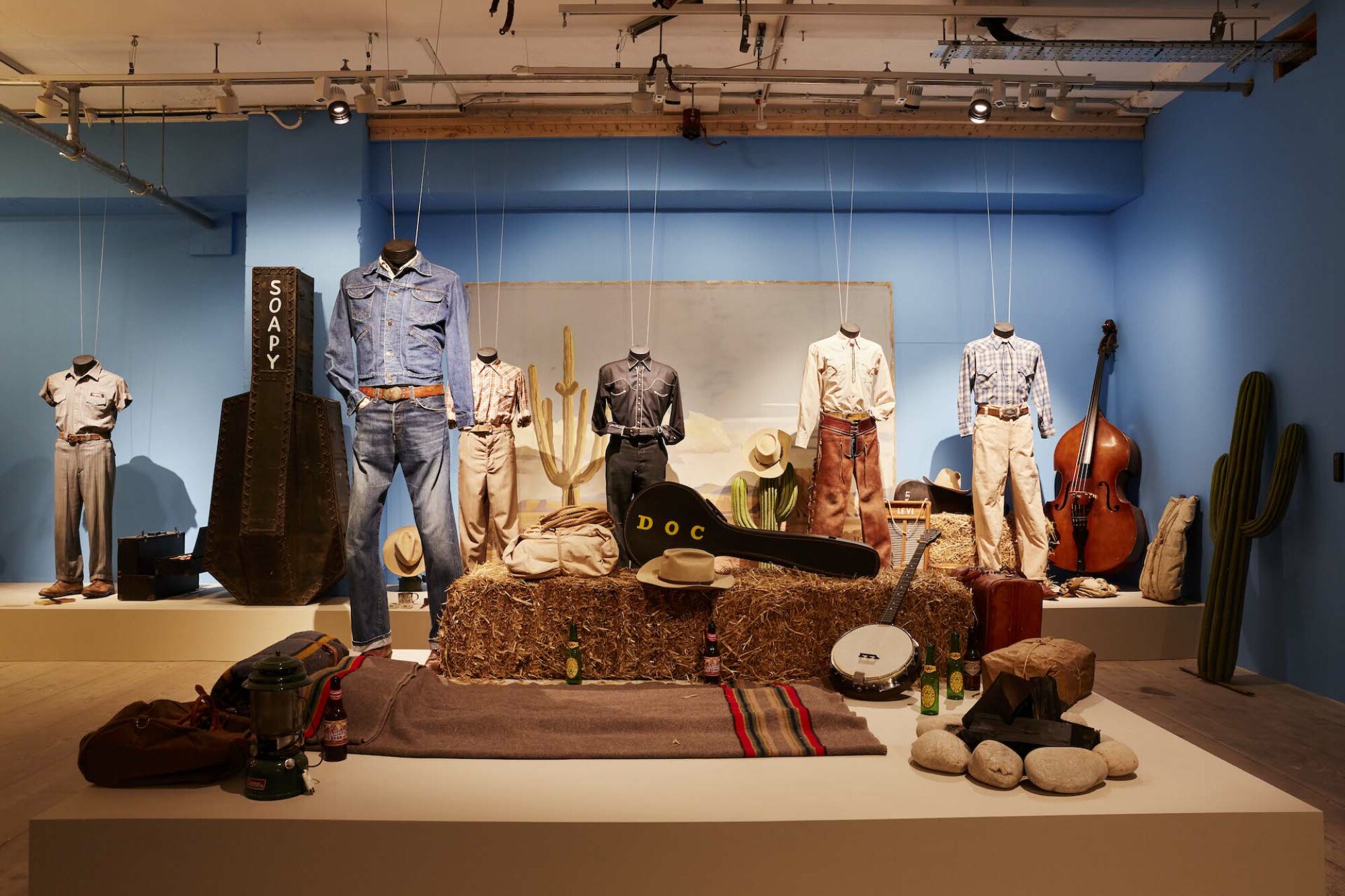 Dans l'exposition 'Asteroid City' à Londres, une collection de tenues de musiciens de cow-boy.