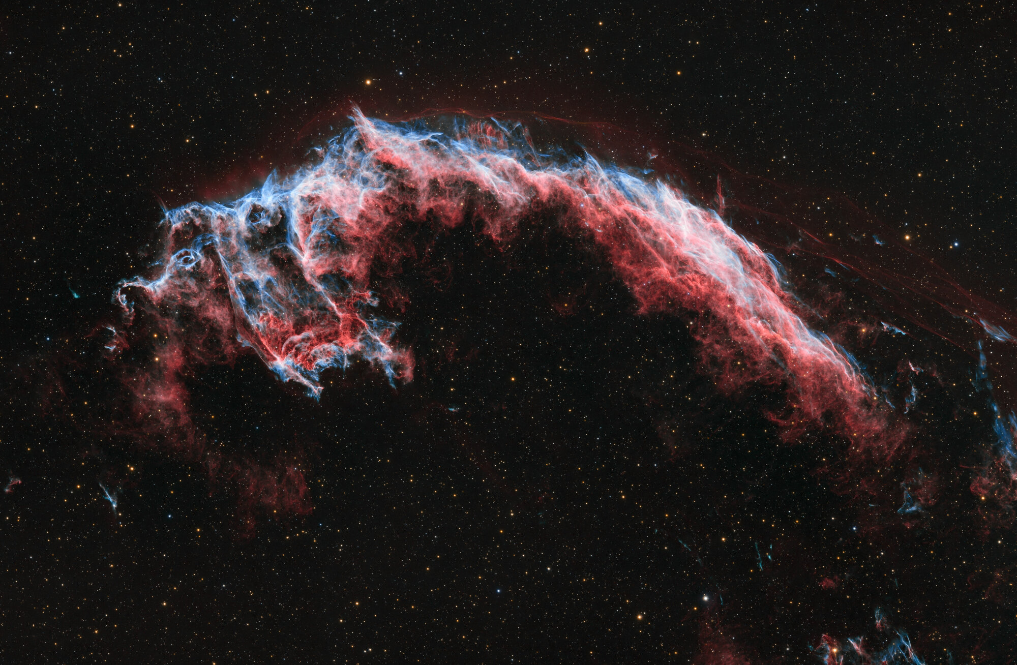 Une nébuleuse rouge et bleue visible dans un ciel noir.