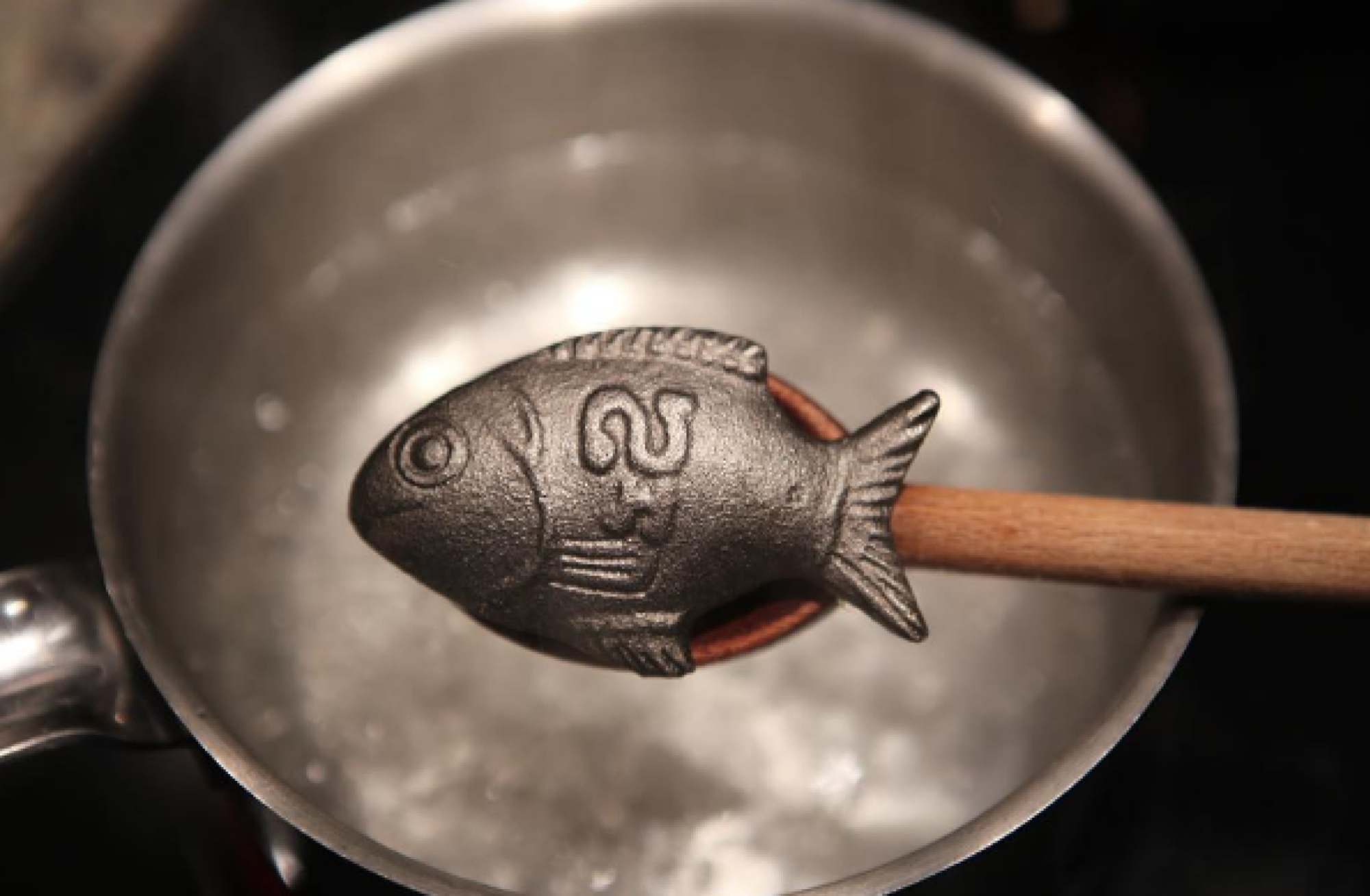 Un Lucky Iron Fish au-dessus d'une casserole d'eau bouillante.