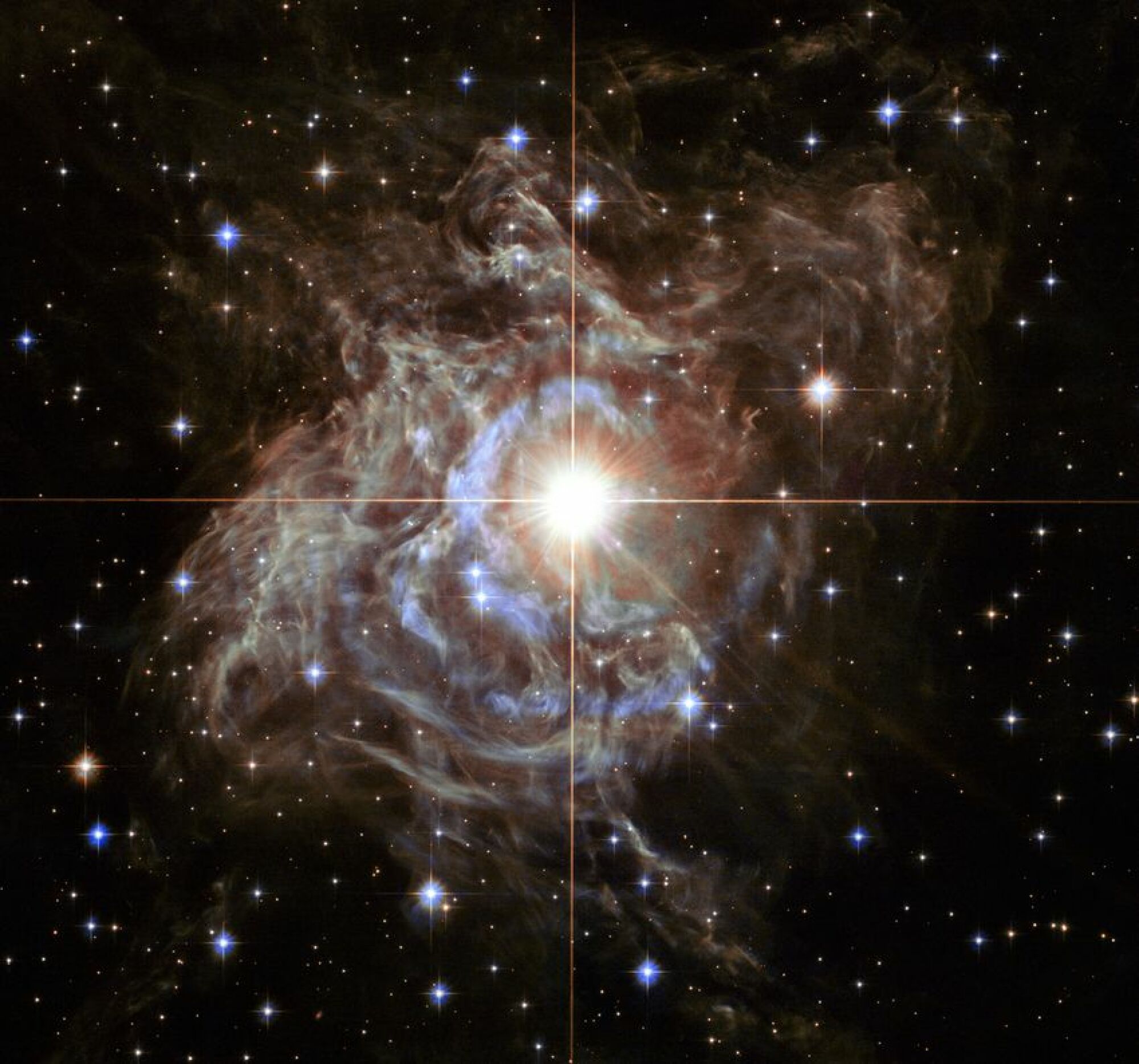 L'étoile brillante de l'hémisphère sud RS Puppis, au centre de l'image, est emmaillotée dans un cocon de poussière réfléchissante illuminé par l'étoile scintillante. 