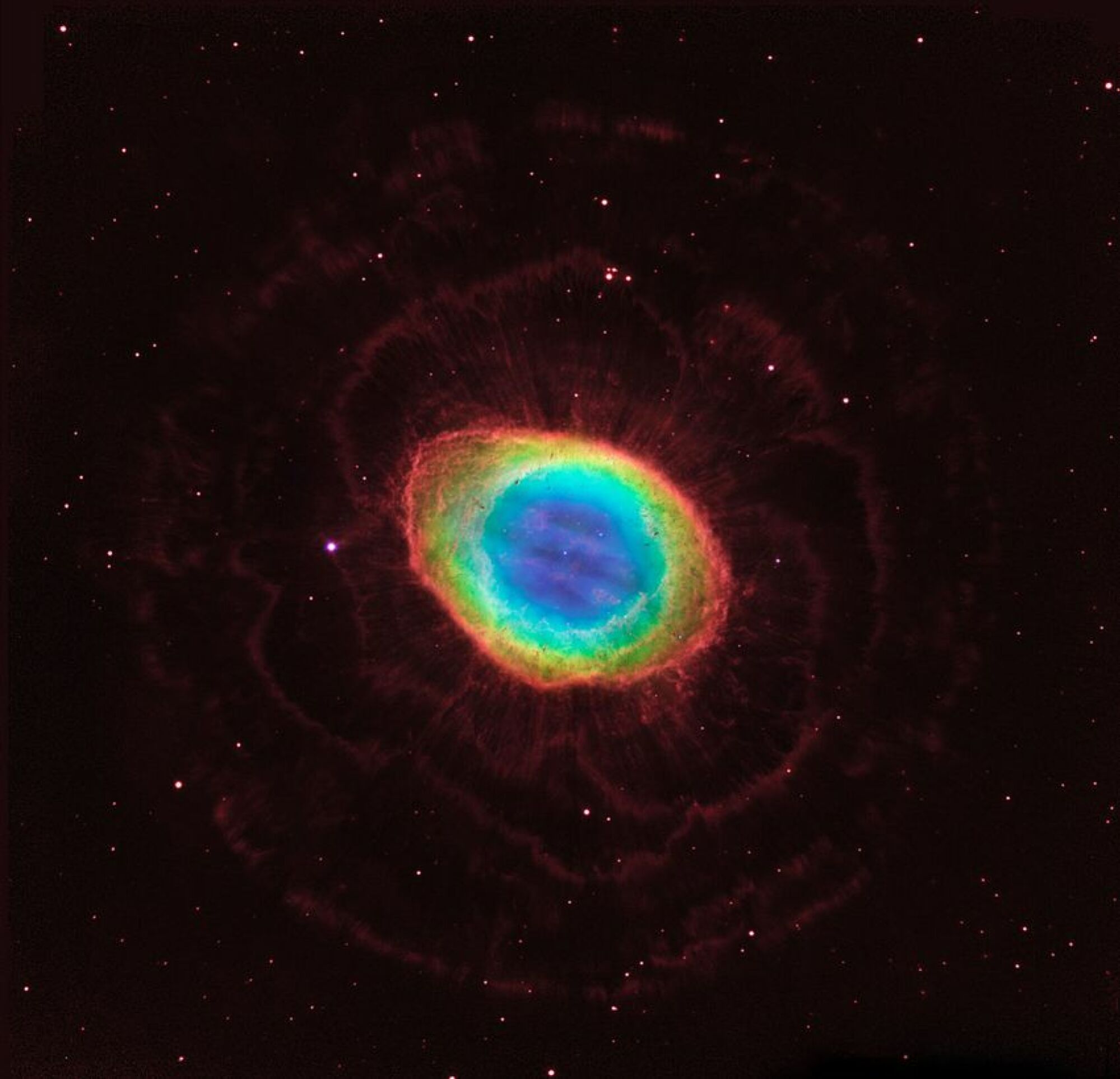 Dans cette image composite, les observations en lumière visible du télescope spatial Hubble de la NASA sont combinées aux données infrarouges du grand télescope binoculaire basé au sol en Arizona pour assembler une vue spectaculaire de la célèbre nébuleuse de l'anneau.