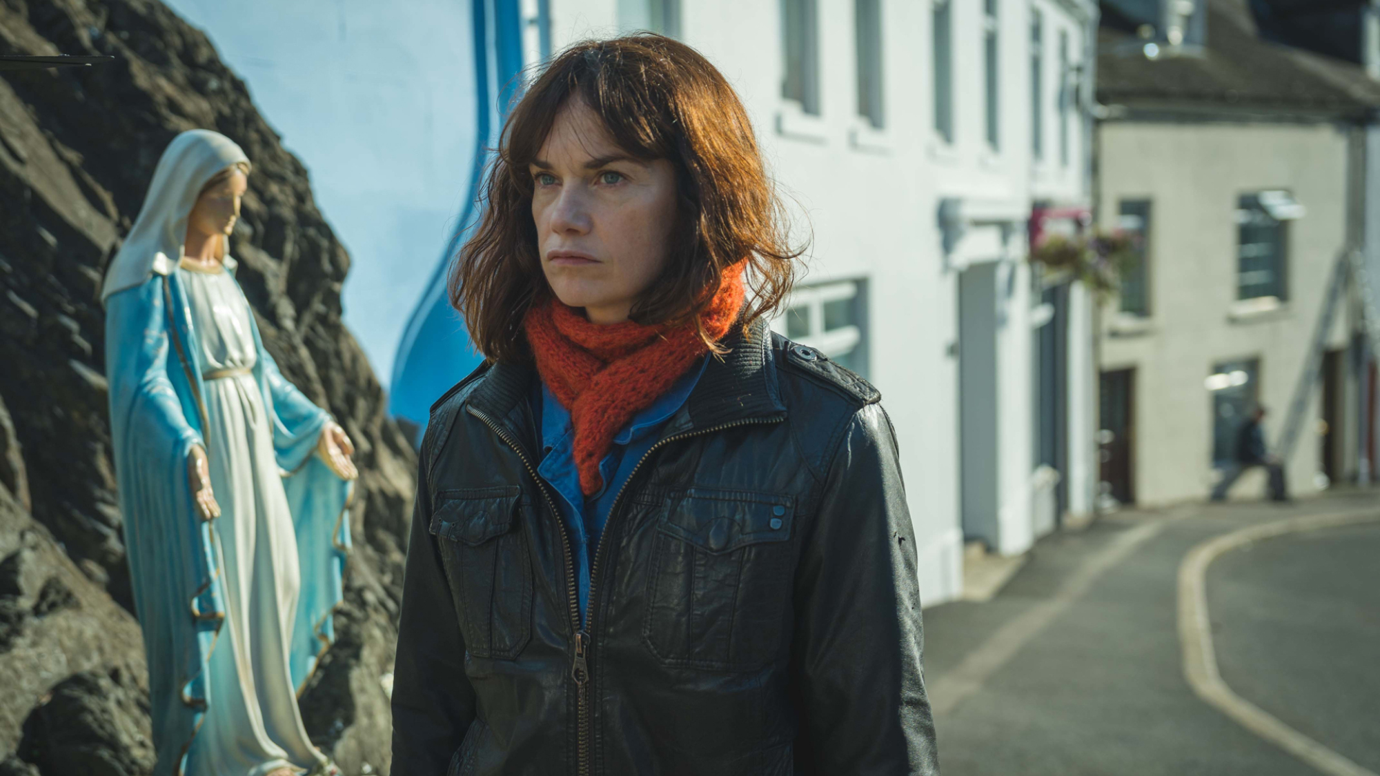 Ruth Wilson marche dans une rue d’une petite ville d’Irlande et croise une figure religieuse de la Madone.