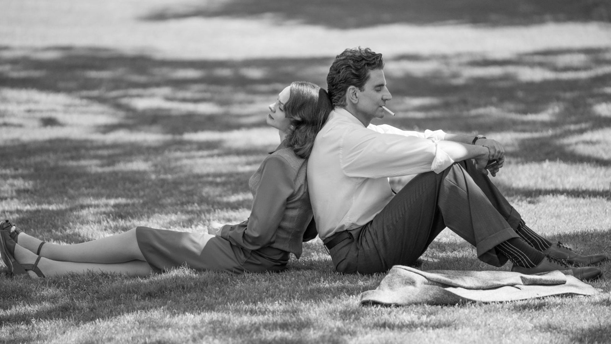 Carey Mulligan et Bradley Cooper dans le rôle de Felicia Montealegre et Leonard Bernstein sont assis dos à dos dans le film "Maestro".
