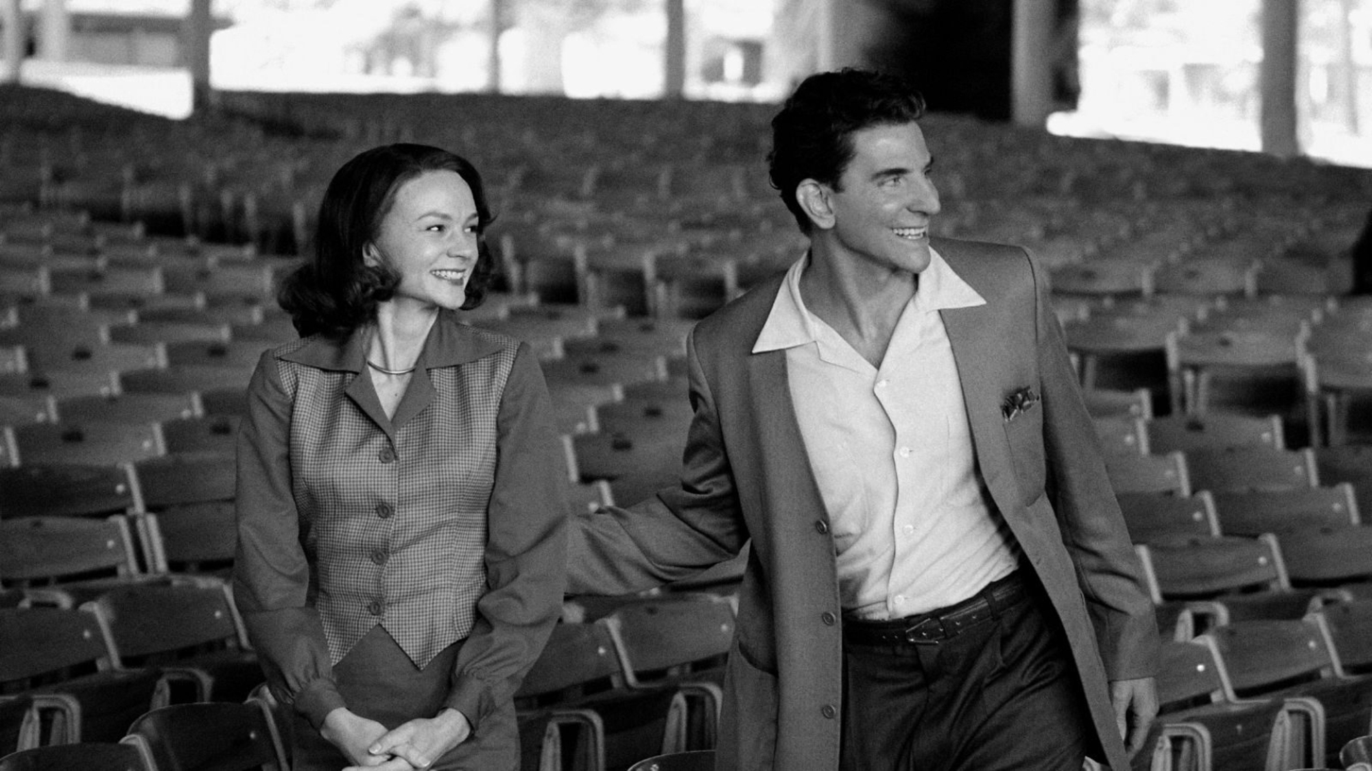 Carey Mulligan et Bradley Cooper dans le rôle de Felicia Montealegre et Leonard Bernstein se tiennent dans un public vide dans le film "Maestro".