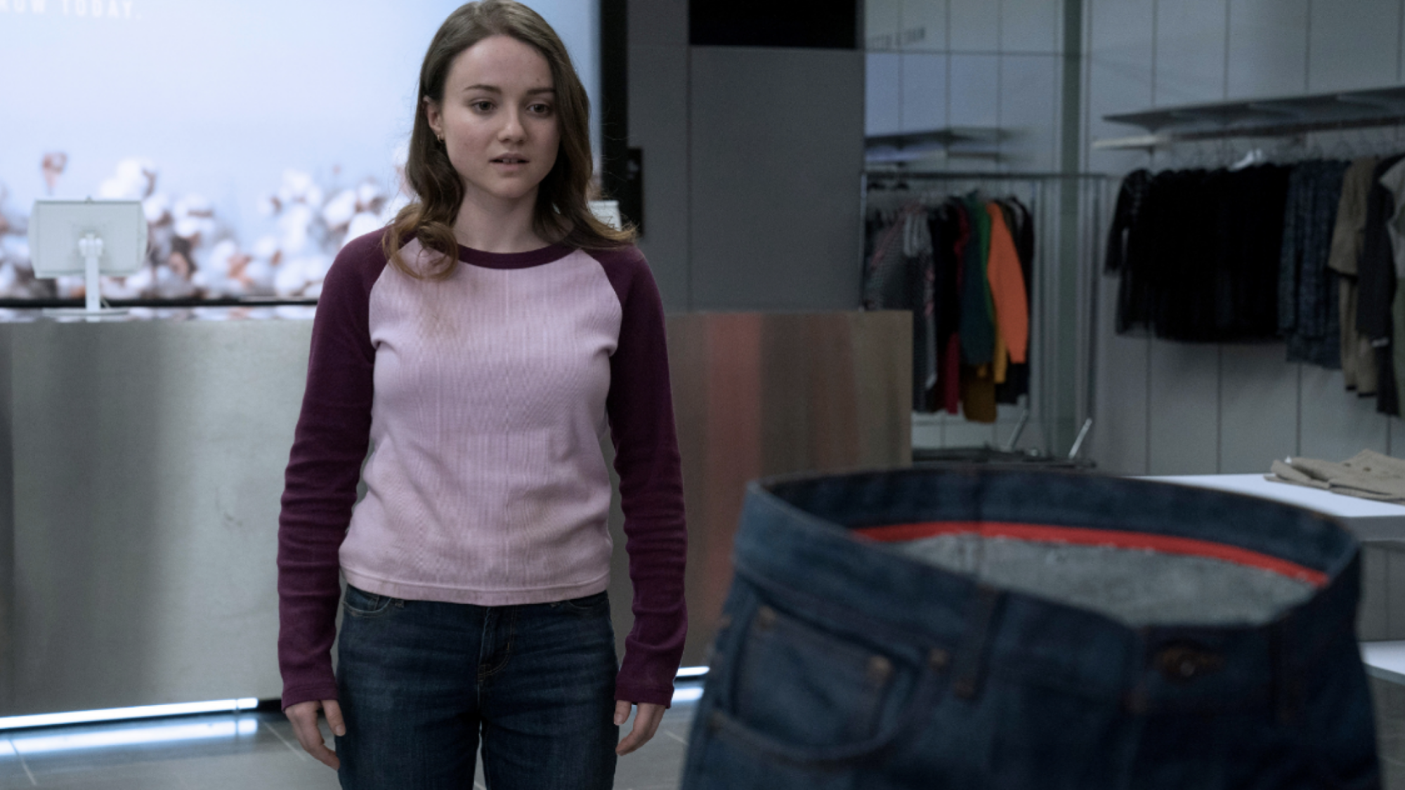 Une femme regarde une paire de jeans.