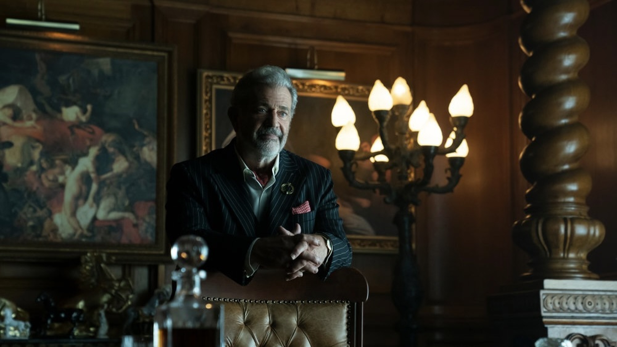 Un homme en costume dans un bureau somptueux.