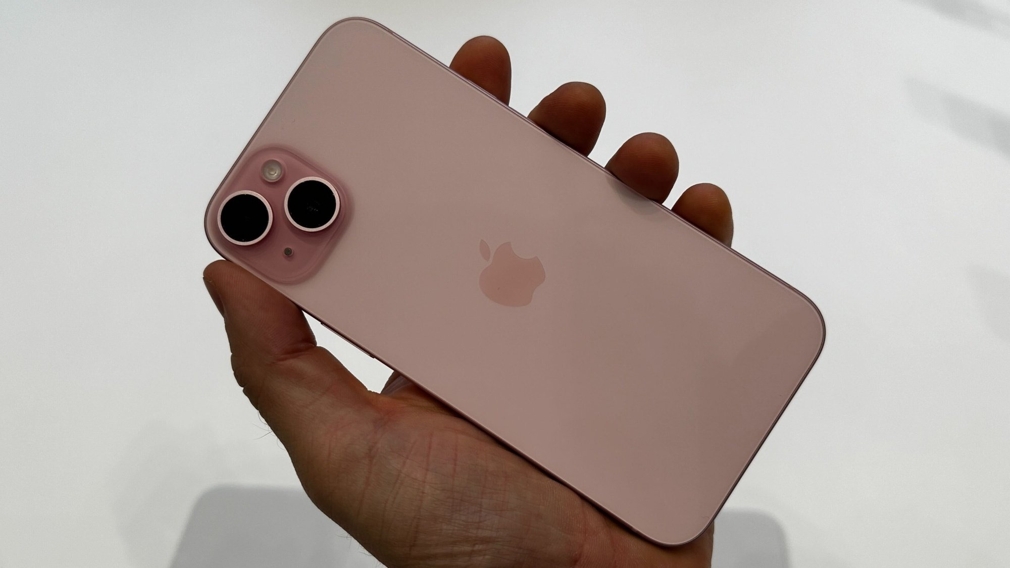 Homme tenant un iPhone 15 rose lors d’un événement Apple