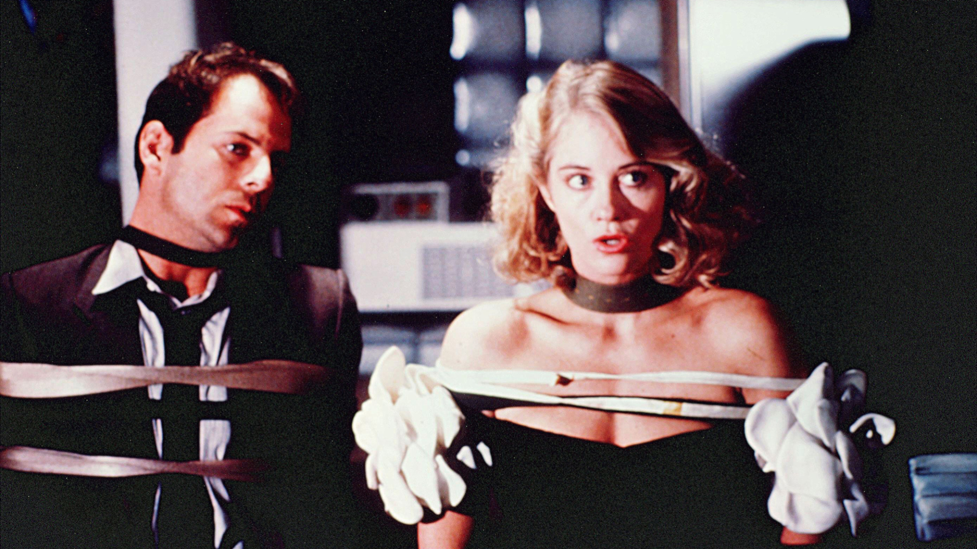 Cybil Shepherd et Bruce Willis portent des tenues de soirée mais sont attachés comme des otages.