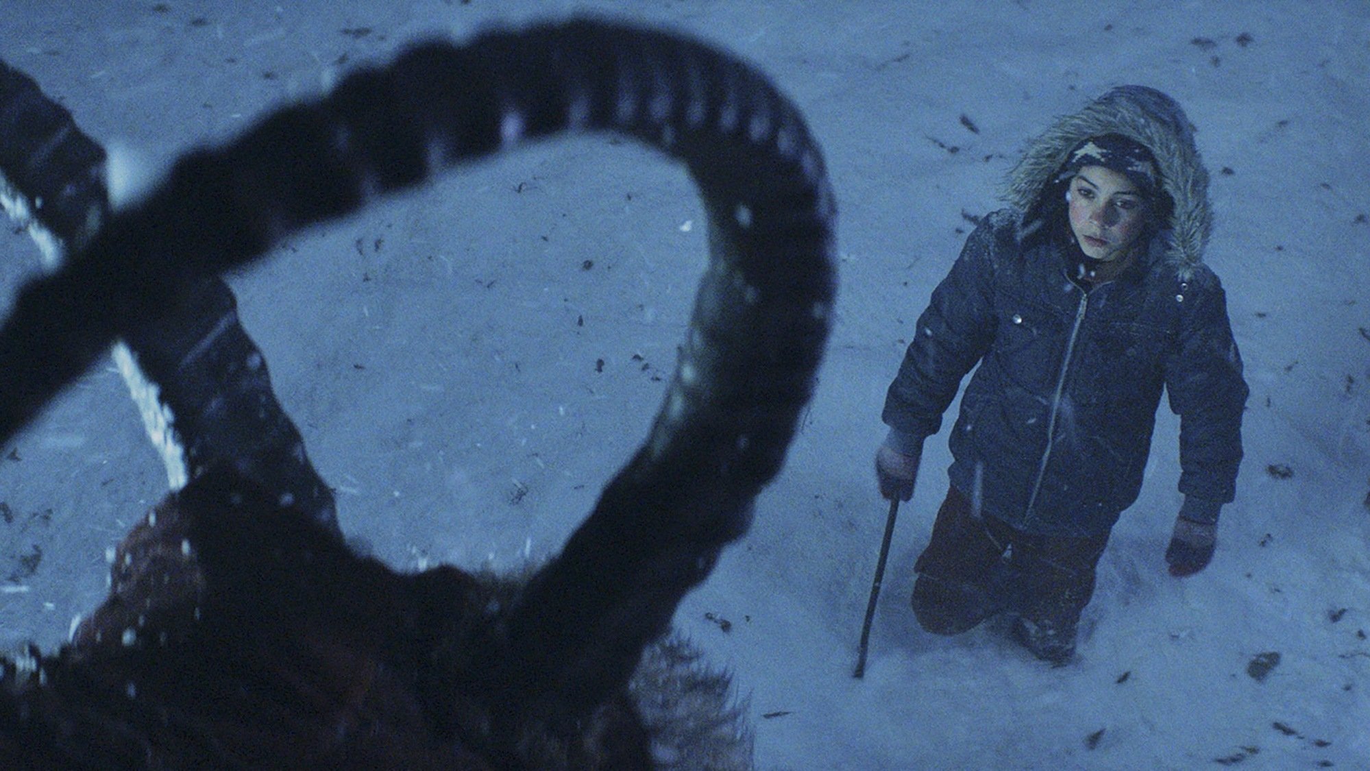 Un garçon (Emjay Anthony) se tient devant un monstre imposant dans « Krampus ».
