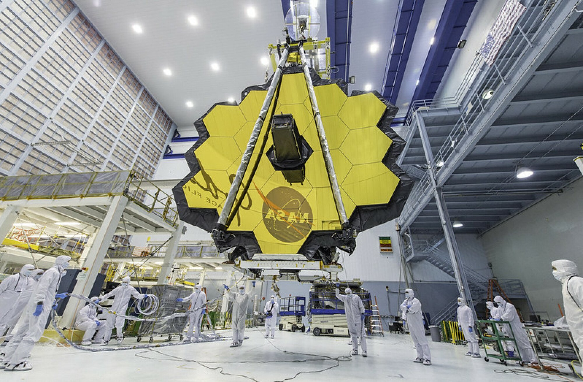 Ingénieurs travaillant sur le miroir géant recouvert d'or du télescope spatial James Webb.