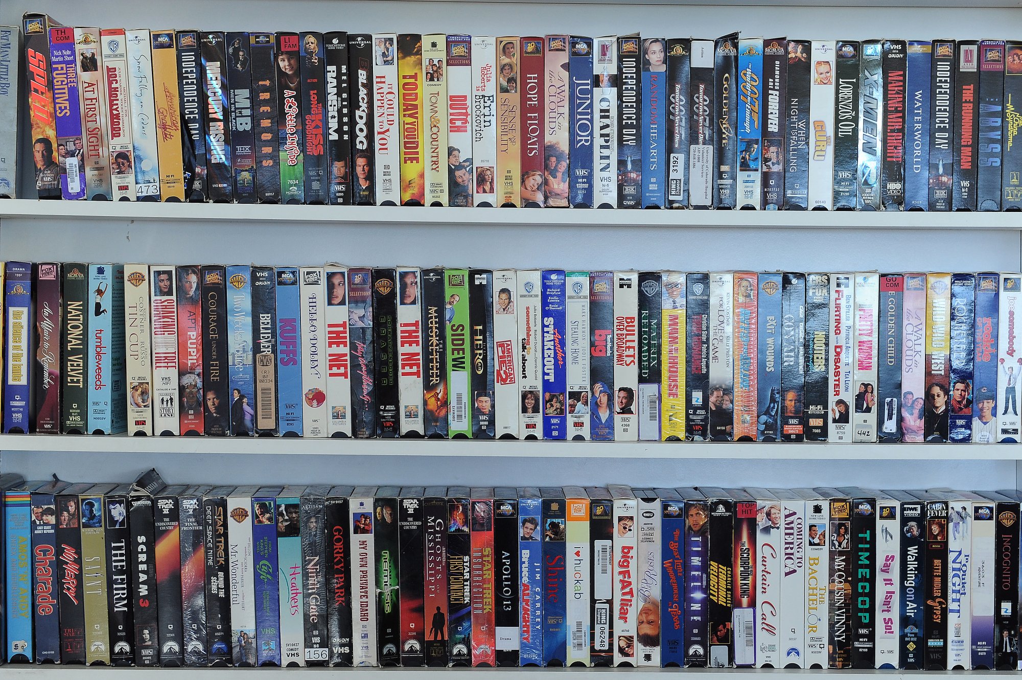 Trois étagères de cassettes VHS.