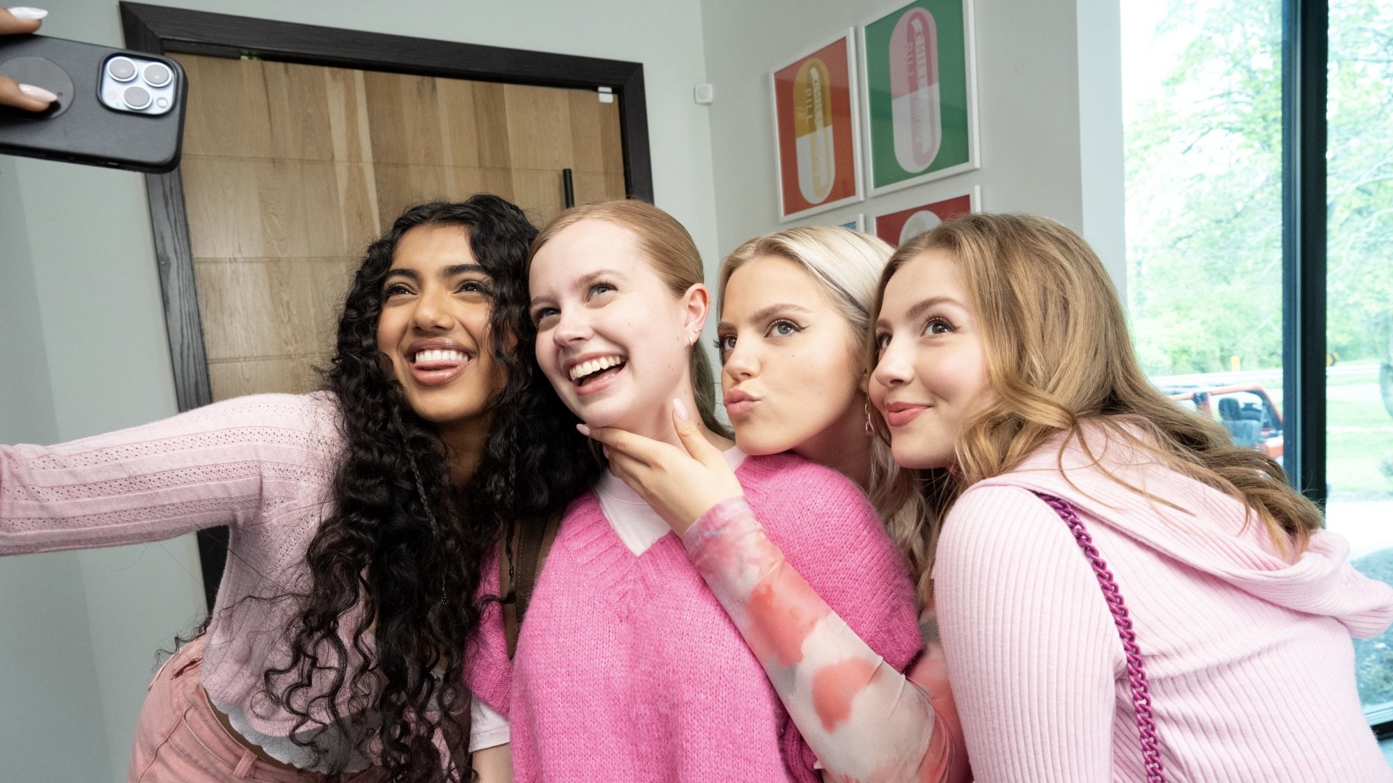 Quatre lycéennes en tenue rose posent pour un selfie.