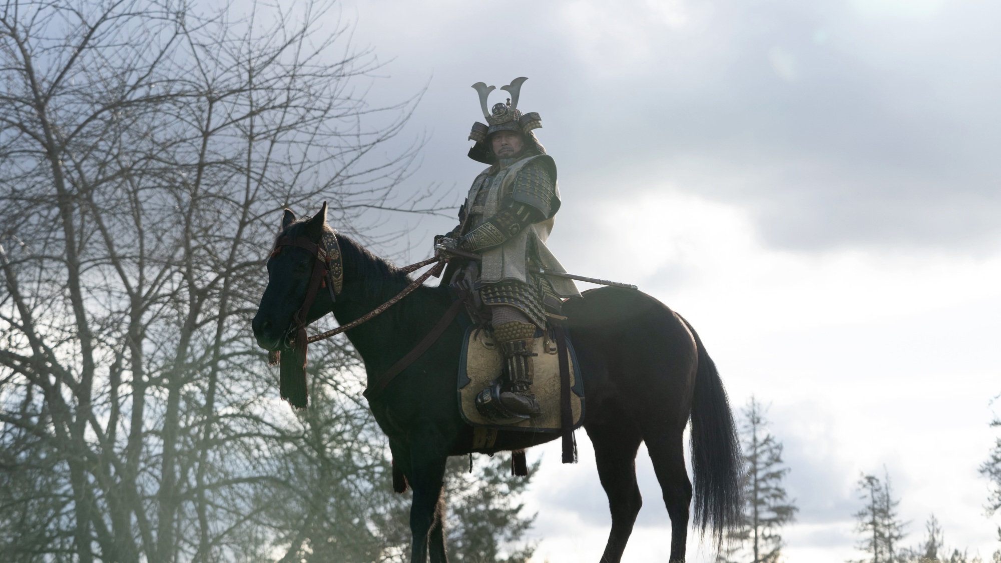 Un homme en armure de samouraï sur un cheval.