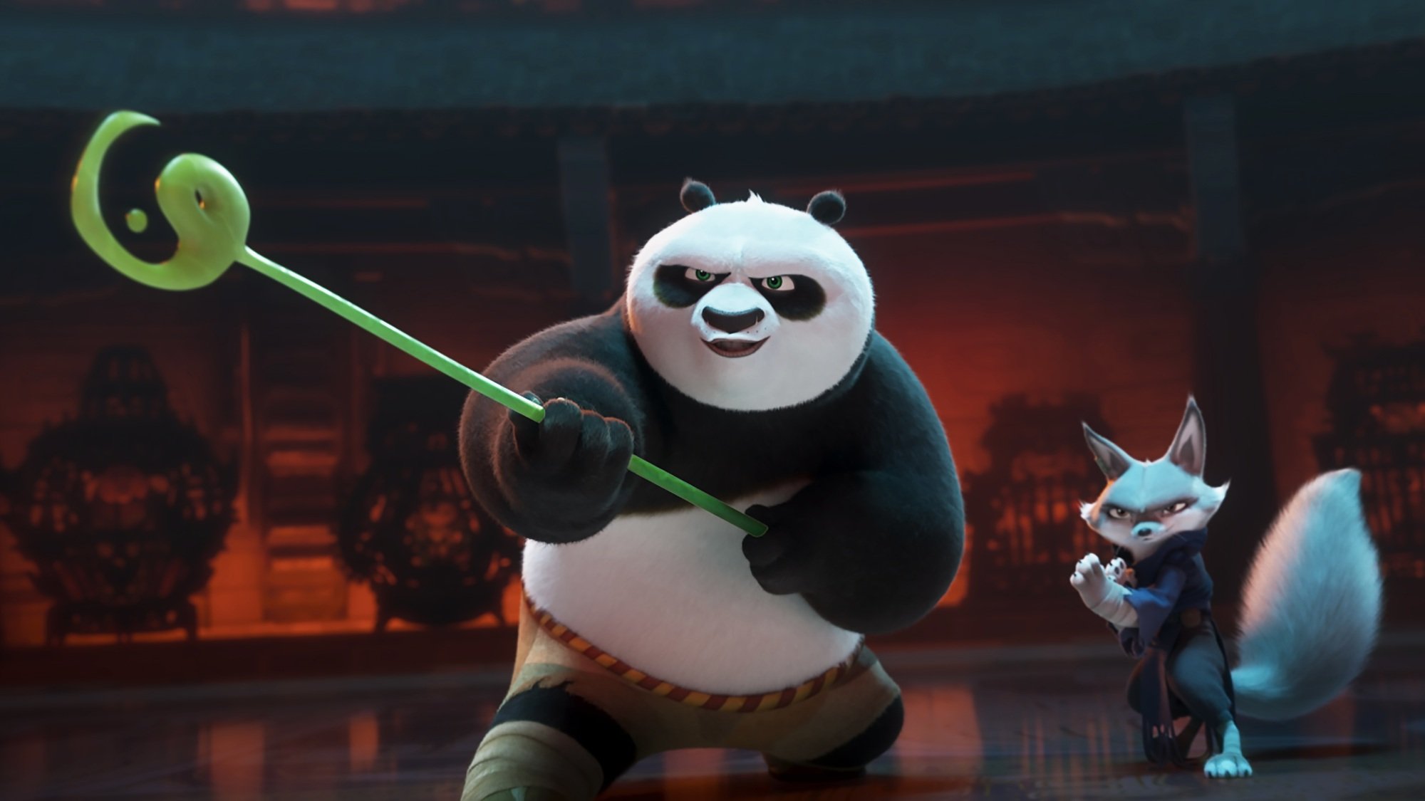 Un panda brandissant un bâton vert et un renard se préparent à se battre.