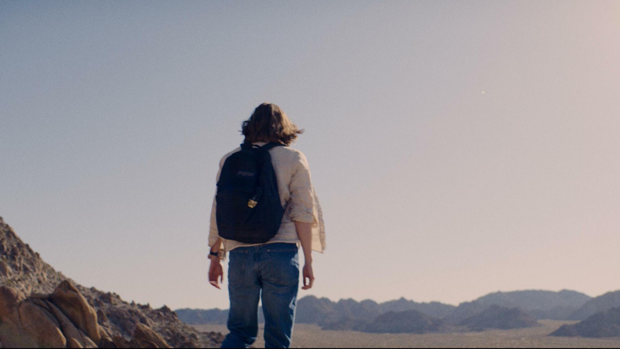 Une femme (Kristine Froseth) regarde le vaste désert devant elle, sans aucun espoir en vue.