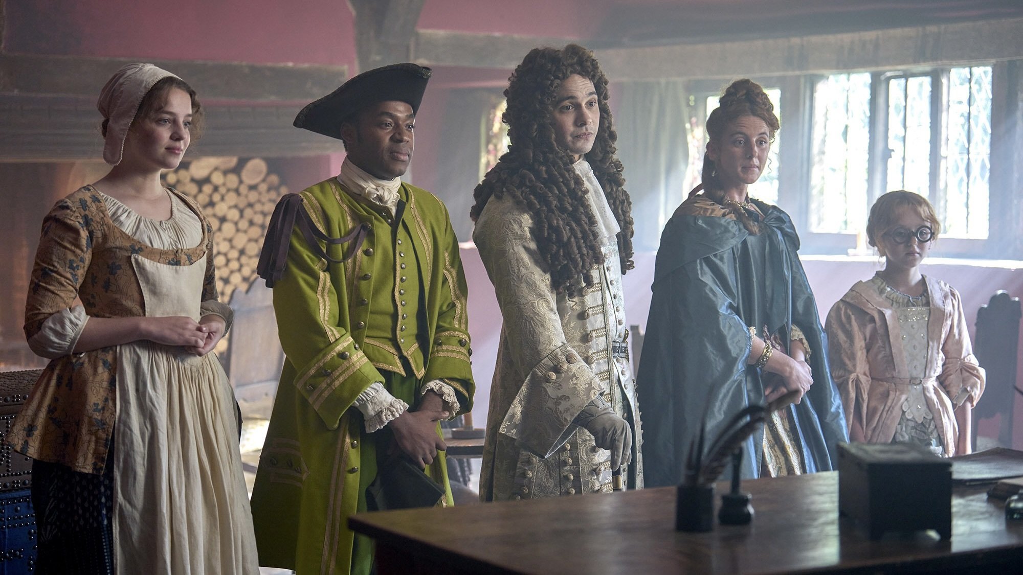 Cinq jeunes hommes et femmes vêtus de vêtements anglais élaborés du XVIIIe siècle s'installent dans une auberge.