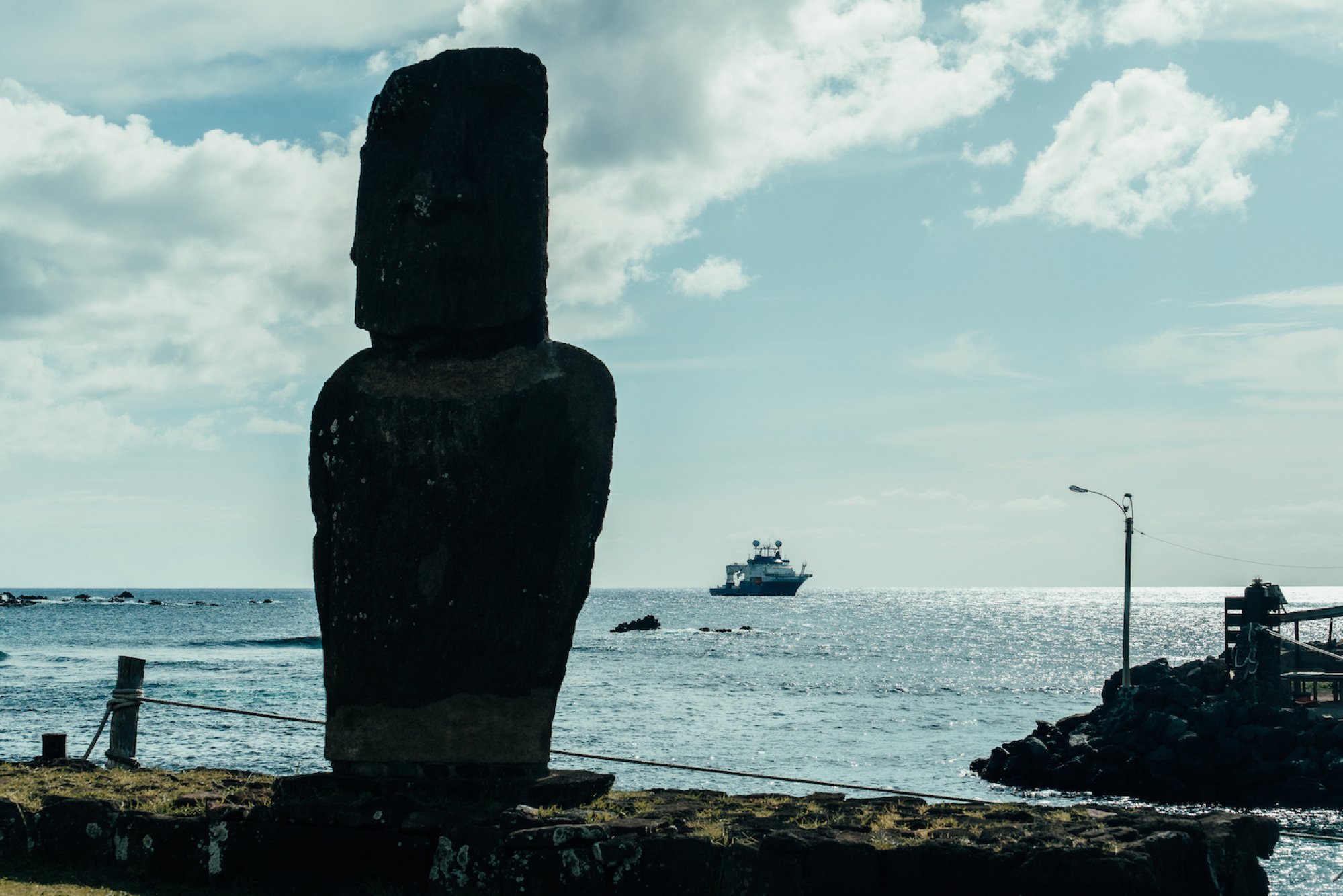 Un moai à Rapa Nui (île de Pâques), avec le navire d'exploration RV Falkor (également) en arrière-plan.