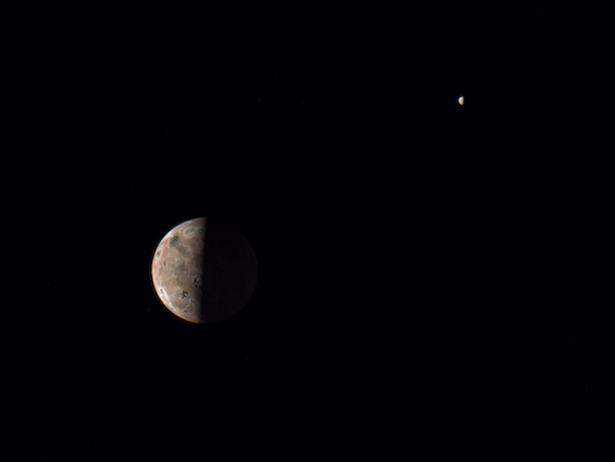 La lune jovienne Io, au premier plan, avec la lune Europe recouverte de glace au loin.