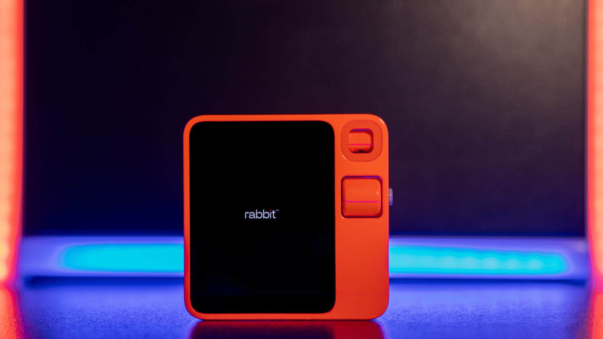 Rabbit R1 sur une plateforme éclairée au néon
