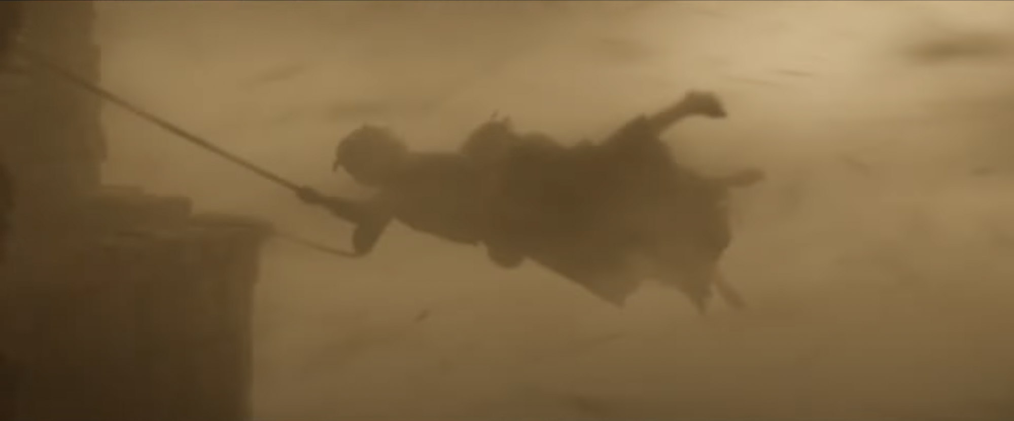 Markella Kavenagh dans le rôle de Nori Brandyfoot dans "Le Seigneur des Anneaux : Les Anneaux du Pouvoir", s'accrochant à une corde lors d'une énorme tempête de sable.