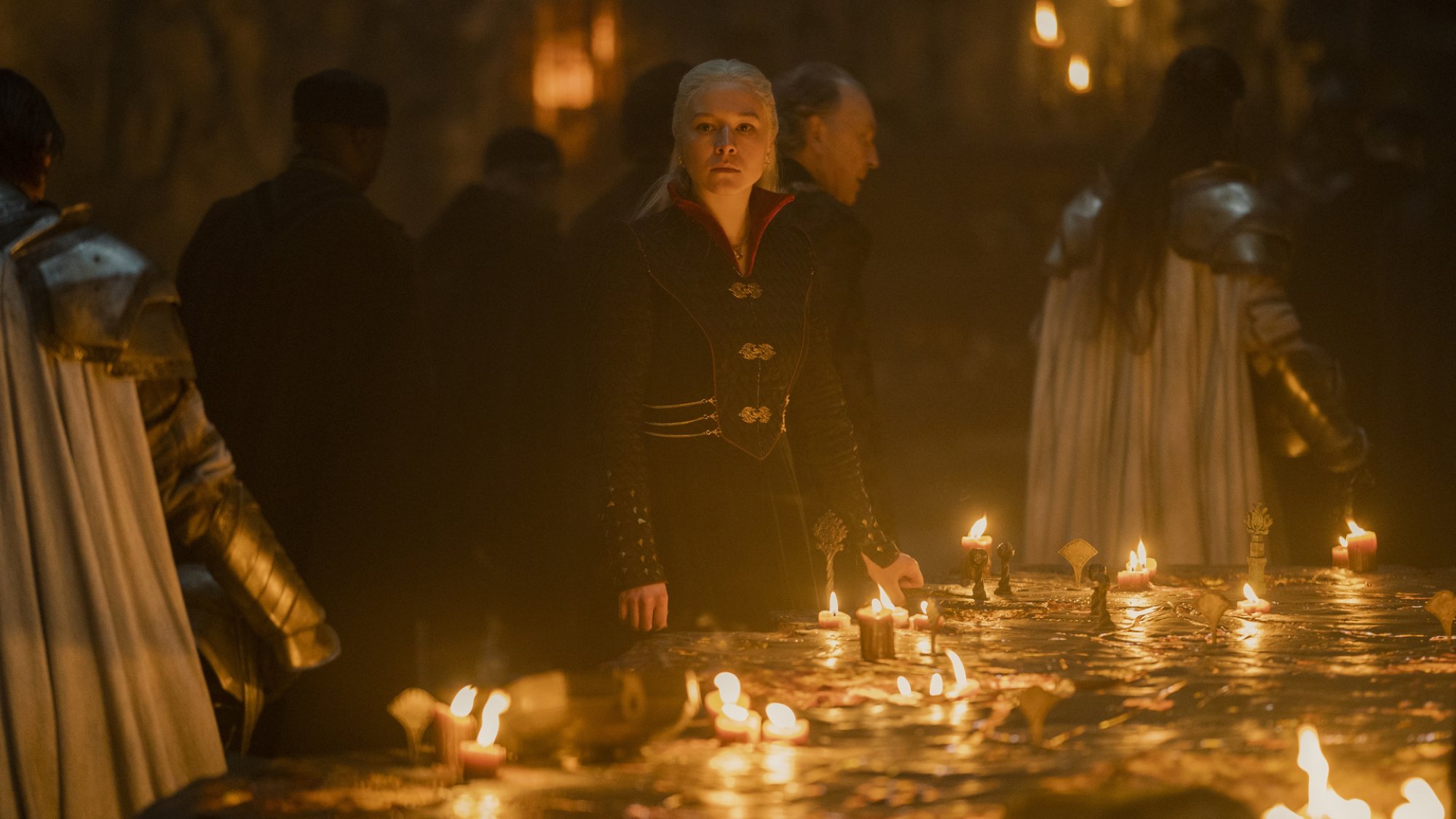 Emma D'Arcy se tient à une table de guerre éclairée aux chandelles dans le rôle de Rhaenyra Targaryen dans "Maison du Dragon."