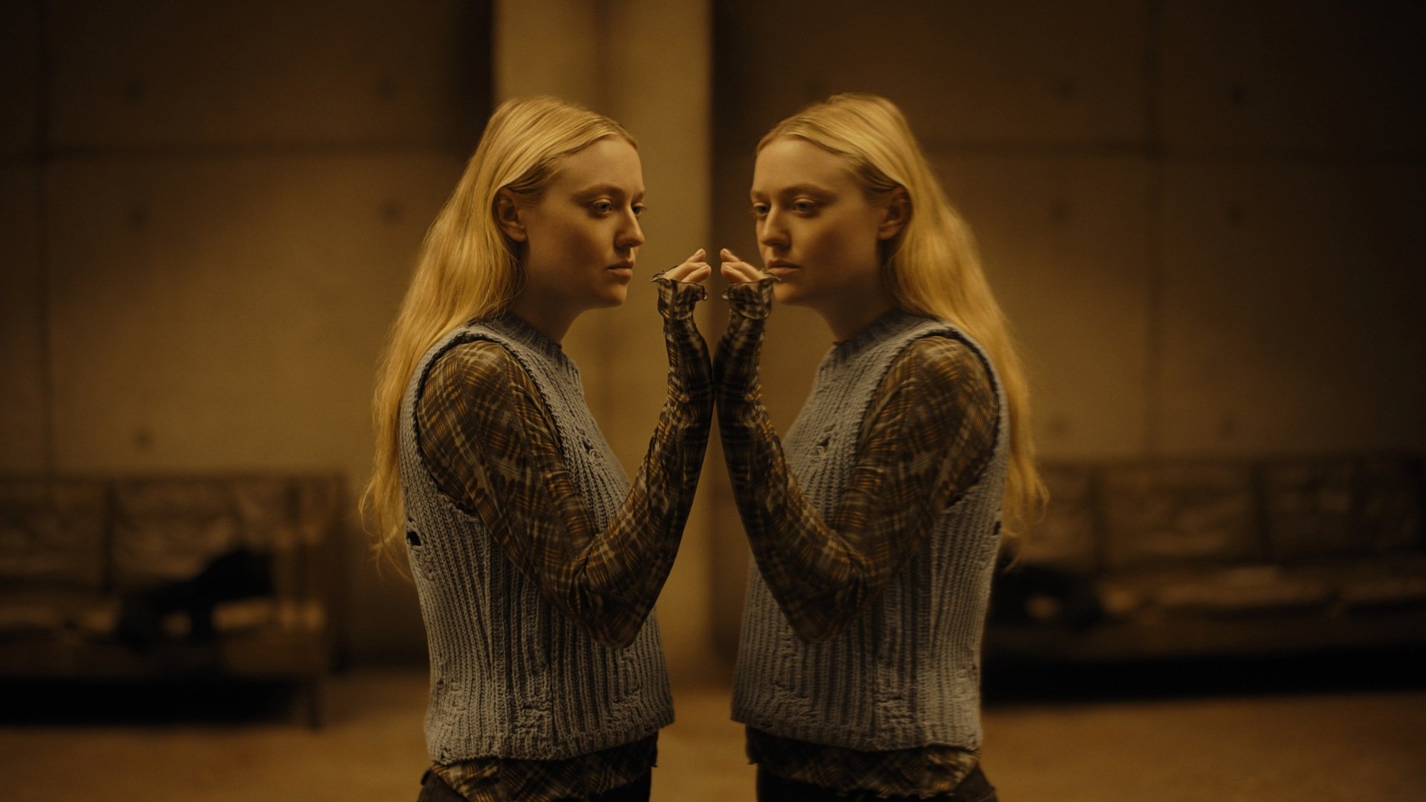 Dakota Fanning se regarde dans un miroir dans "The Watchers".