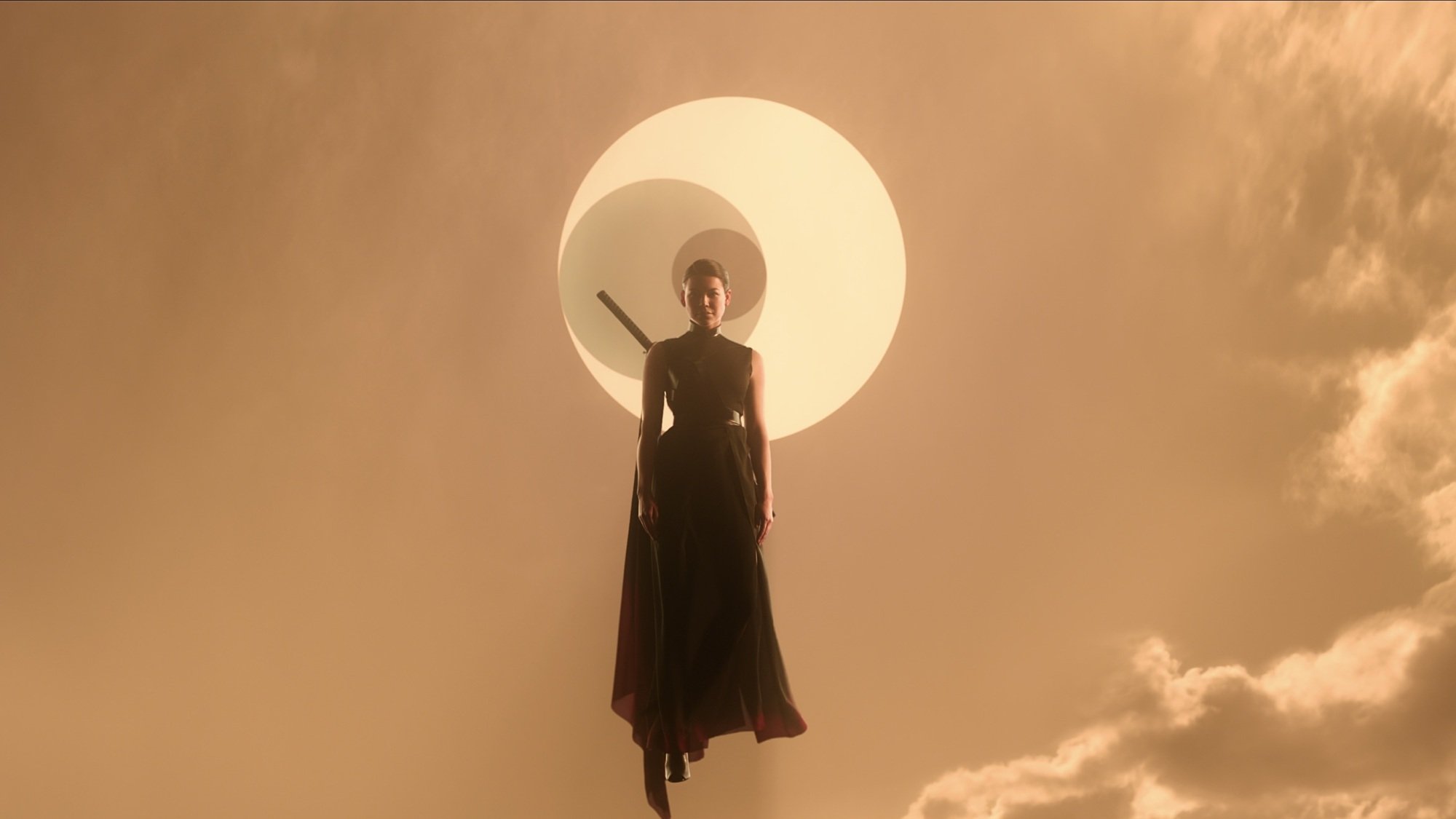 Une femme avec une épée attachée au dos flotte dans un ciel orange contre un symbole de trois symboles imbriqués.