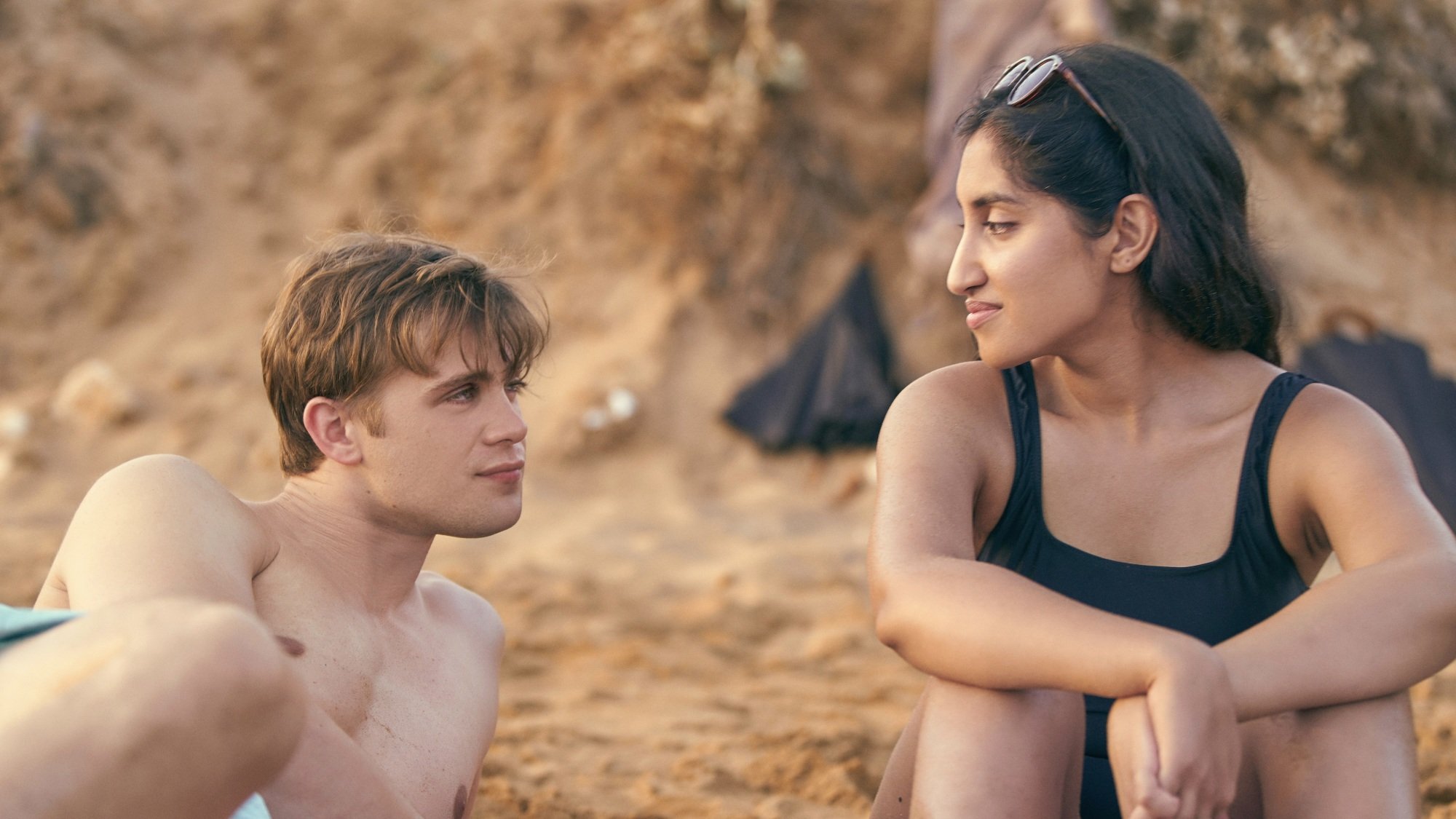 Un homme et une femme se regardent sur une plage.