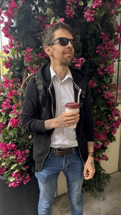 Homme debout devant un bouquet de roses roses