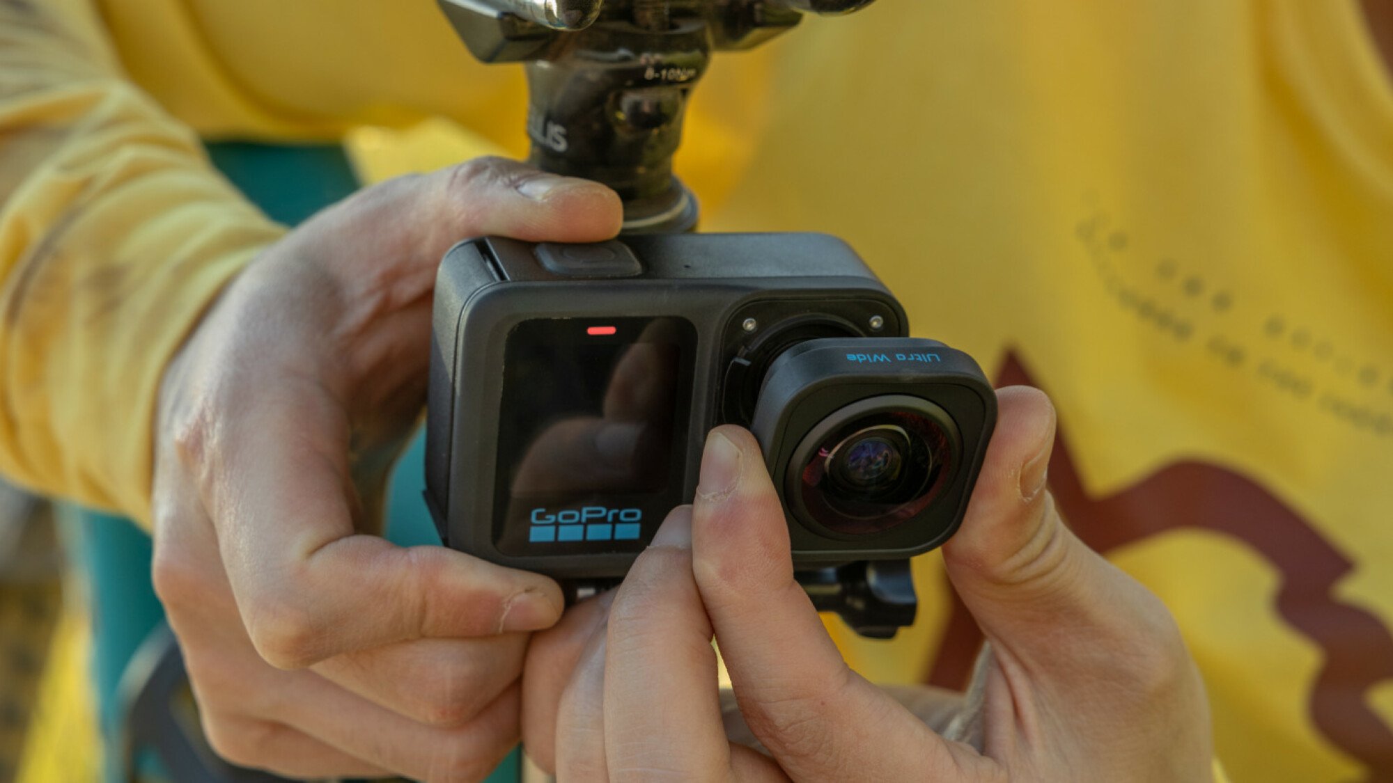 Une personne retirant l'objectif ultra large de la GoPro HERO13 Black.