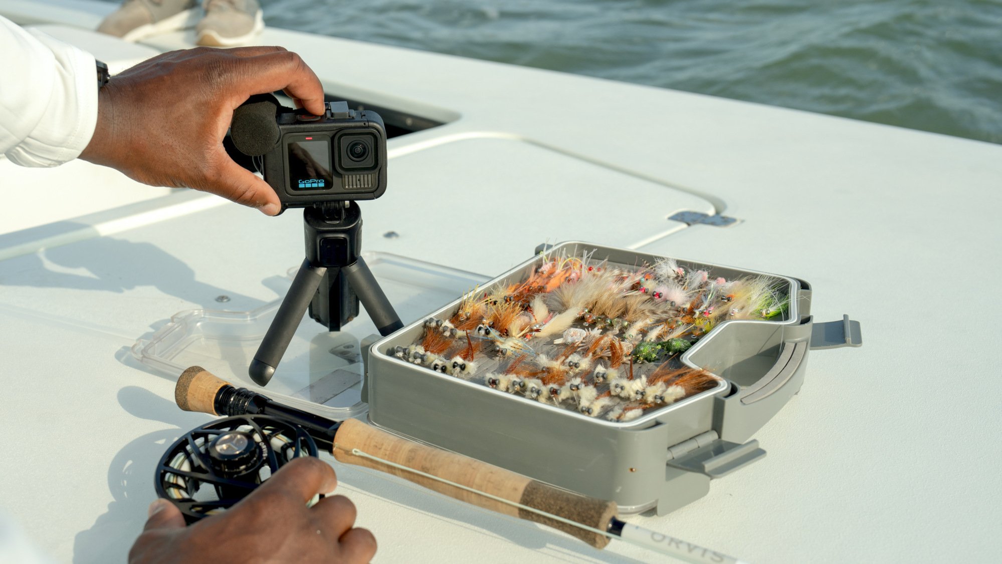 pêcheur utilisant gopro hero13 black sur un bateau avec moulinet et matériel de pêche