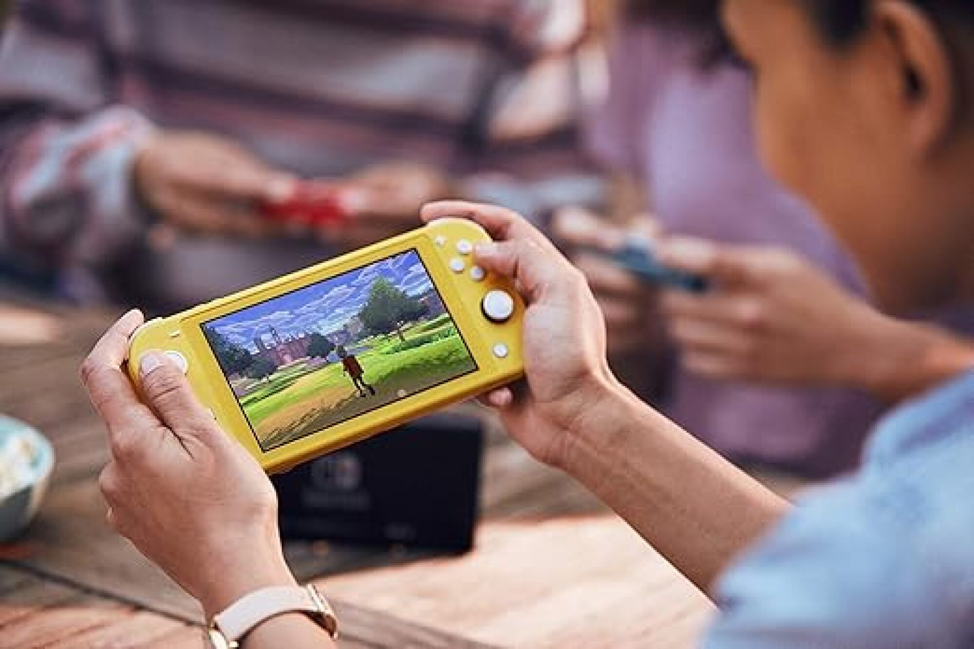 personne jouant à la Switch Lite en jaune