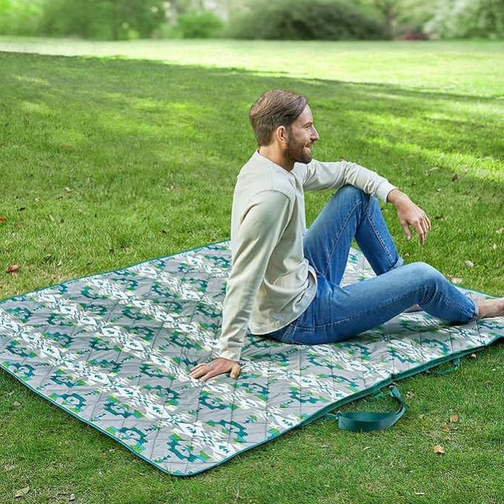 homme assis sur une couverture à l'extérieur