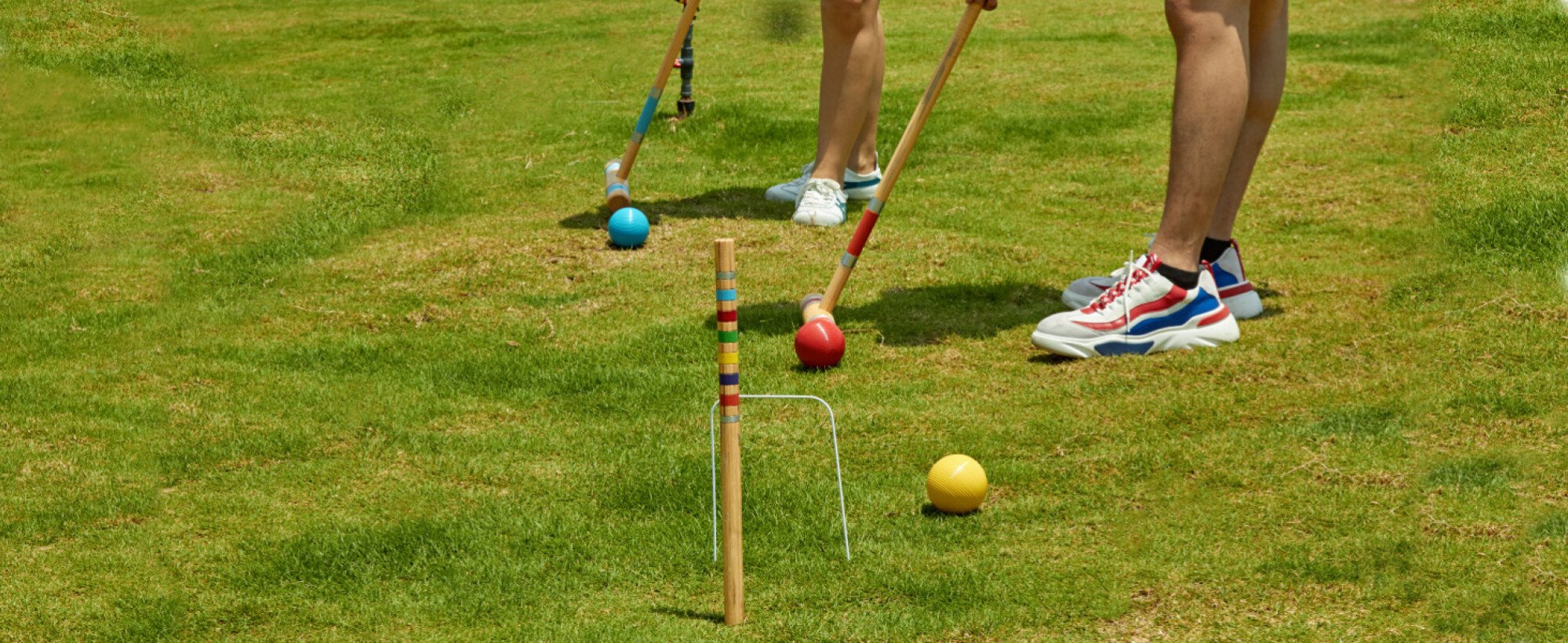 deux personnes jouant au croquet