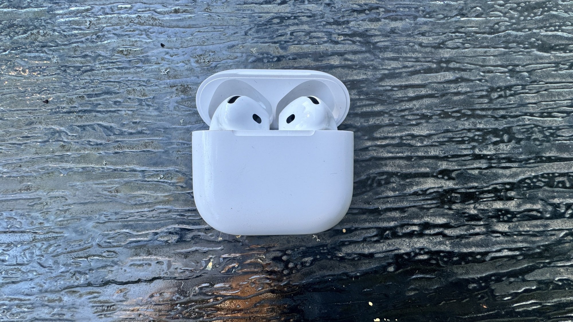 Airpods 4 sur une table en verre