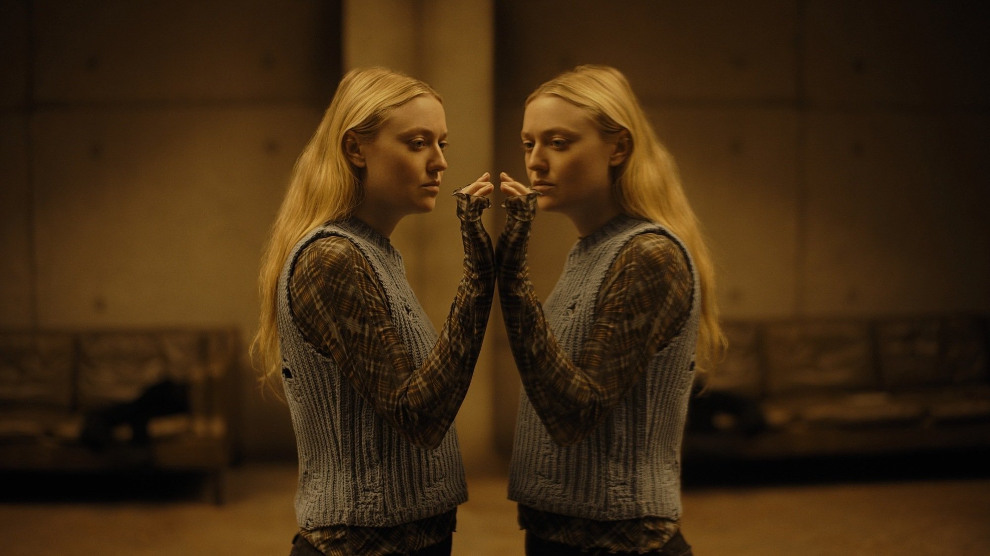 Dakota Fanning regarde son reflet dans une image tirée du film « The Watchers »