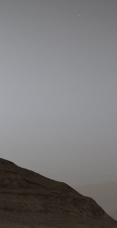 La lune Phobos et la Terre visibles en haut à droite. 