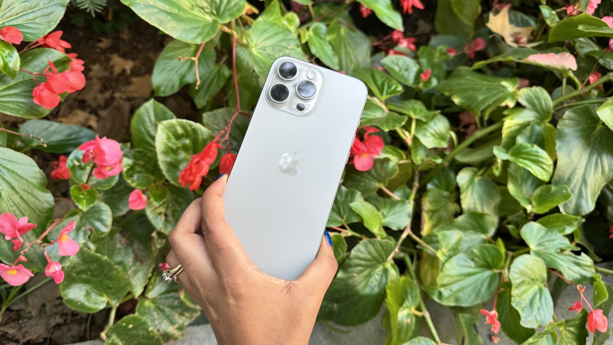 iPhone 16 Pro Max devant une composition florale