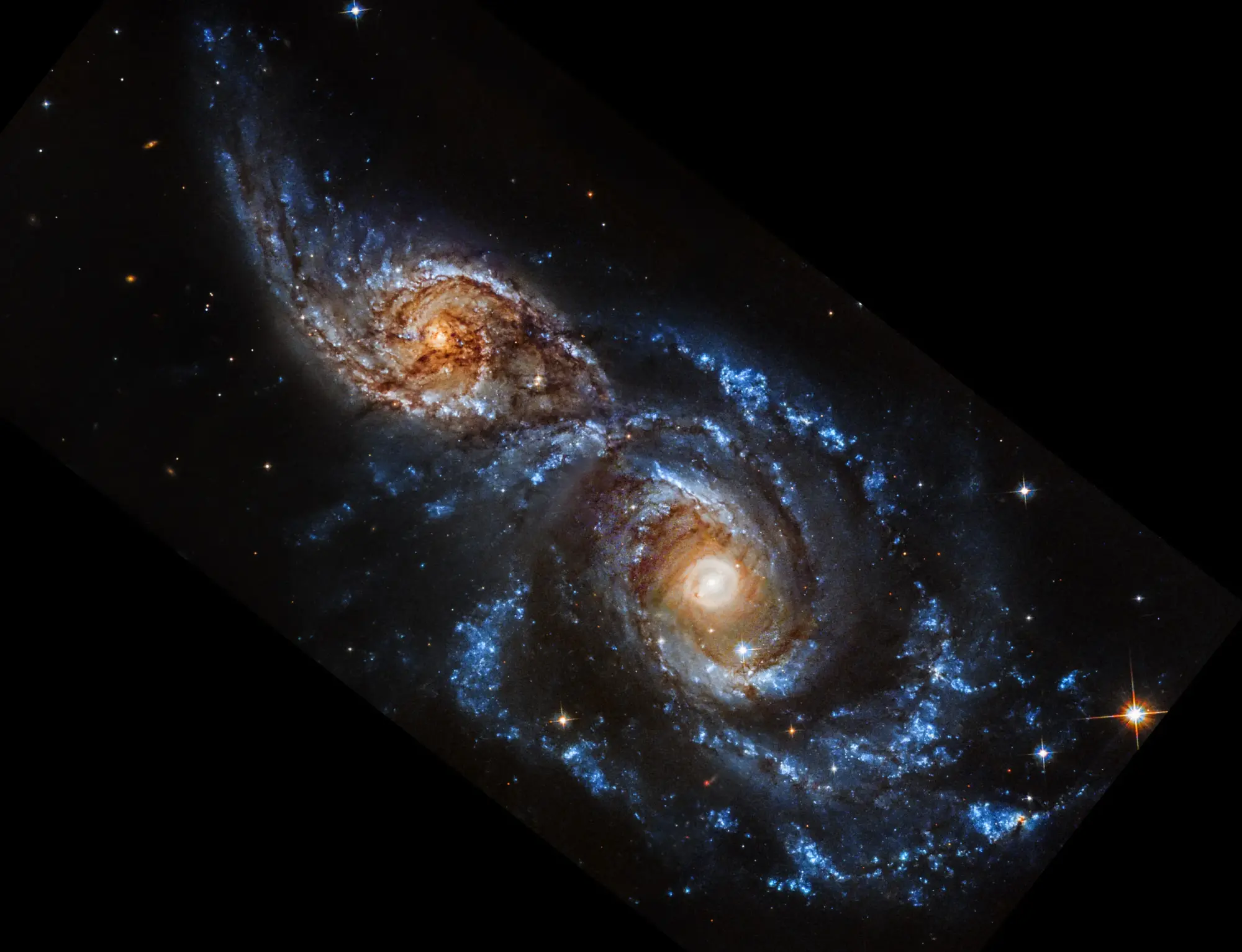 Deux galaxies sur le point de fusionner sous la lumière ultraviolette.