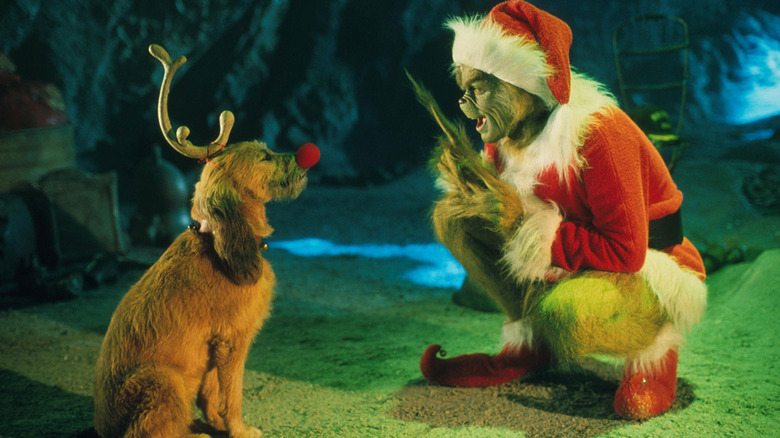 Le Grinch accroupi à côté de son chien Max dans Comment le Grinch a volé Noël